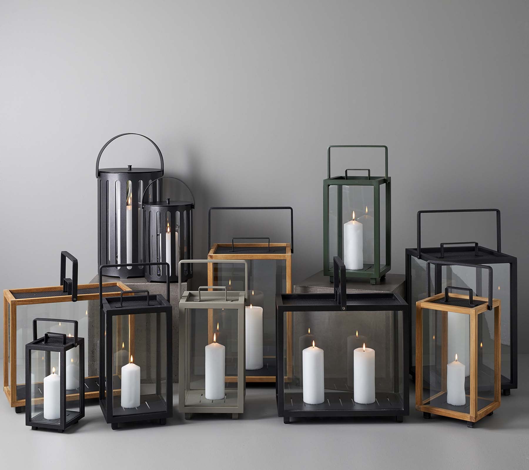 Een collectie elegante lantaarns in verschillende maten en stijlen, met kaarsen binnenin, samen gerangschikt op een neutrale achtergrond.