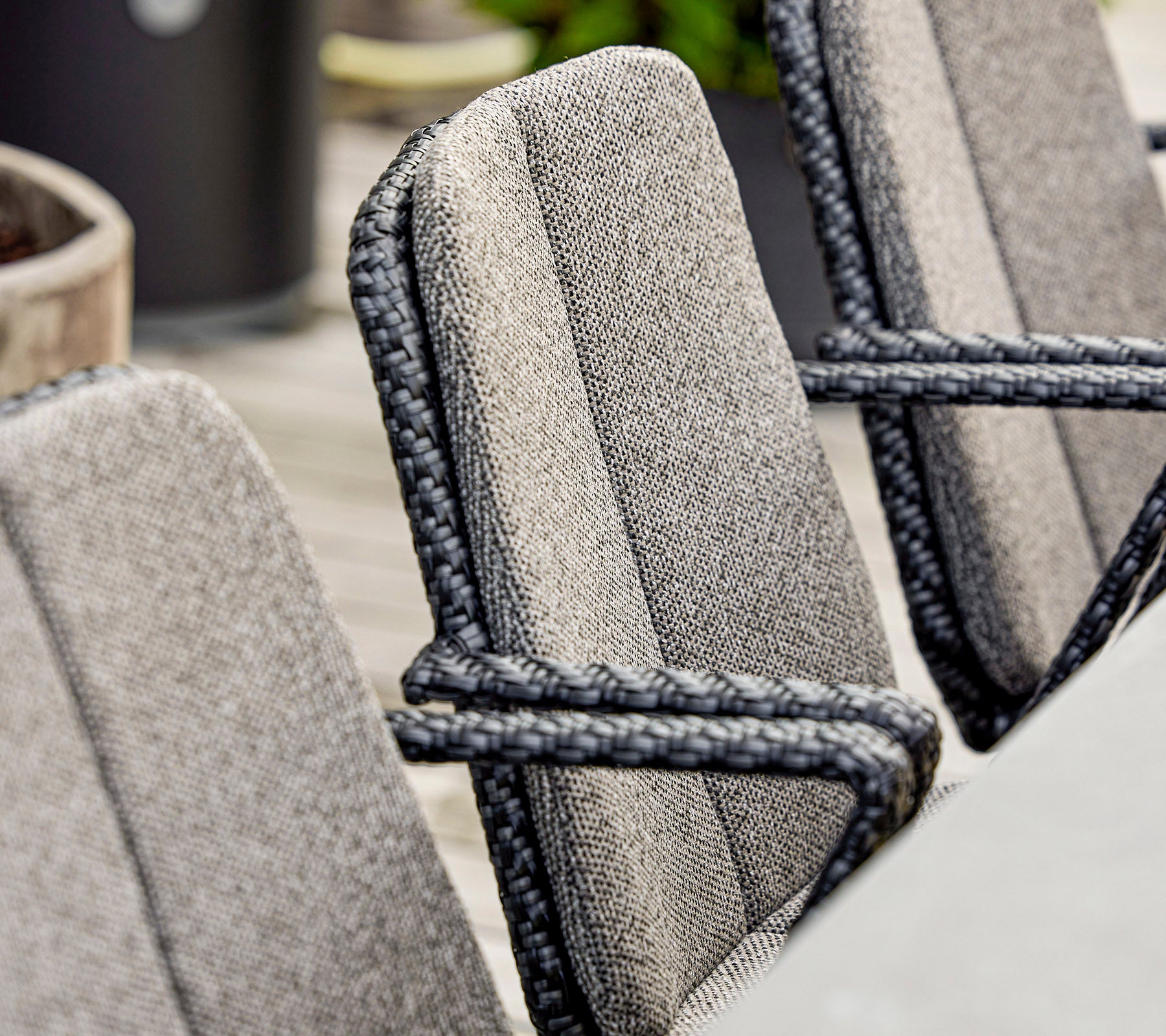 Close-up van stijlvolle stoelen met textiel met textuur en elegante touwdetails, geschikt voor moderne buitensitplaatsen.