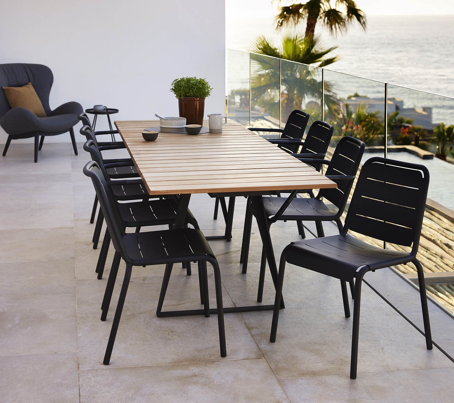Een Kopenhagen-tafel met een houten blad omringd door zwarte Kopenhagen-stoelen, wat een stijlvolle eetopstelling creëert.
