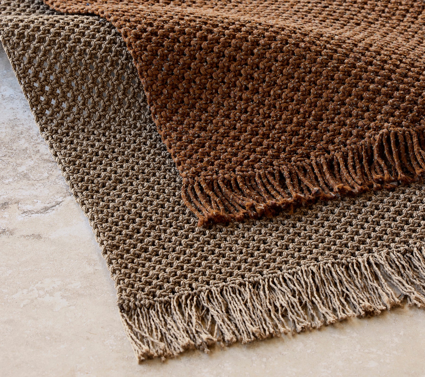 Gebreide tapijt van 240x170 cm in een gestructureerd patroon met franjes, in warme bruine tinten.