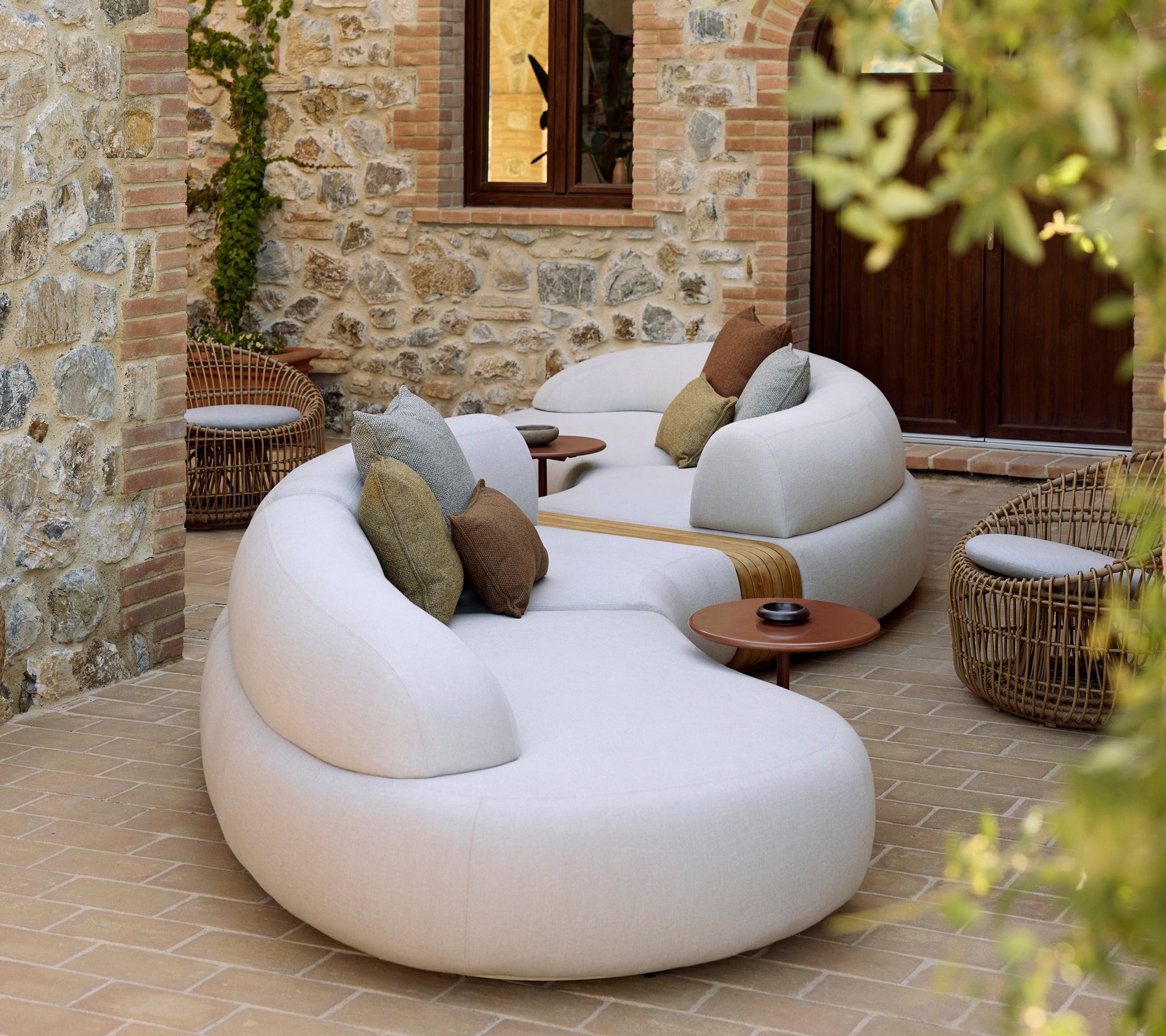 Zachte lounge met een Nest ronde stoel en Glaze salontafel, aangevuld met decoratieve kussens in een rustige setting.