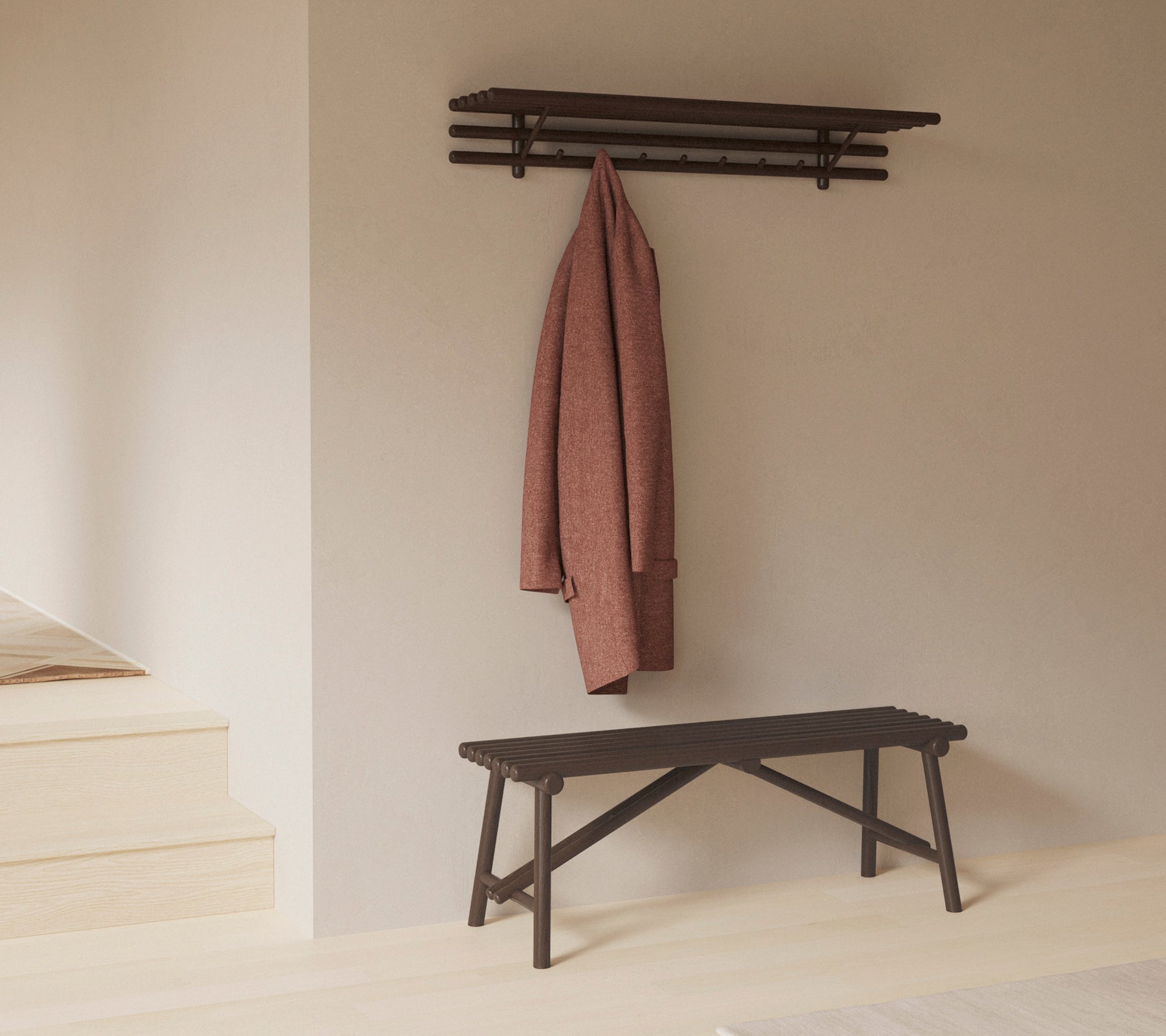 Een minimalistische bank met een plank erboven, die een jas toont die aan haken hangt, en de nadruk legt op eenvoud en functionaliteit in het ontwerp.