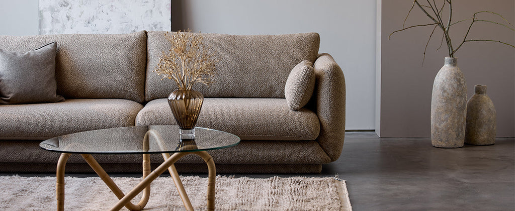 Omslagfoto van de Bloom 3-zitsbank in Kimi-Flair-stof in de kleur taupe, met de Wave salontafel ervoor