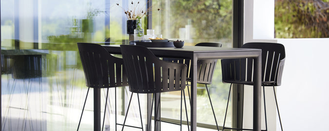 Moderne bartafel met bijpassende barkrukken, met een strak design en minimalistische esthetiek, perfect voor sociale bijeenkomsten en ontspanning.