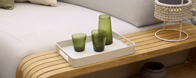 Moderne lounge-instelling met groen glas op een wit dienblad.