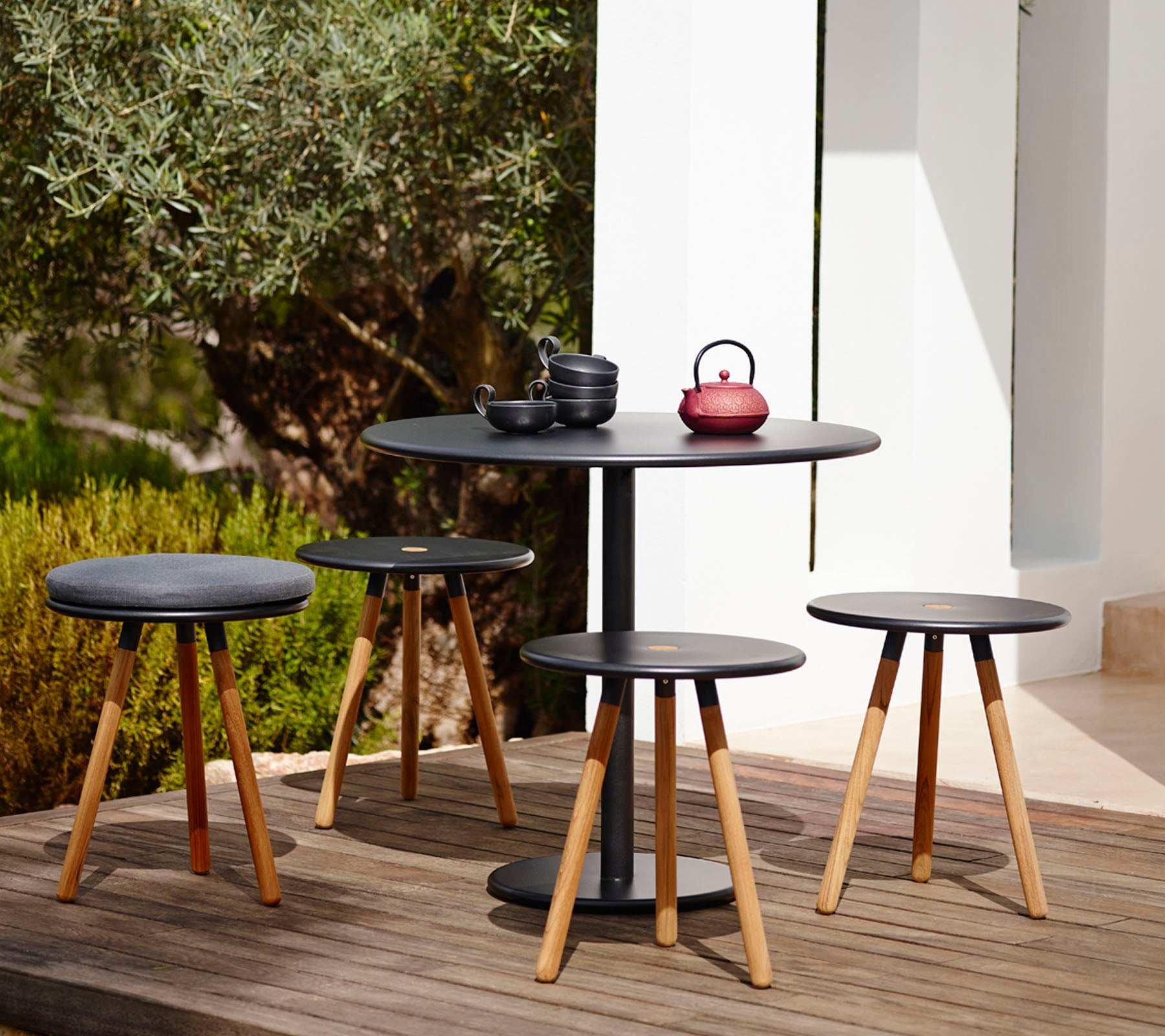 Modern zwart tafel- en stoelset in een buitentuinsetting.