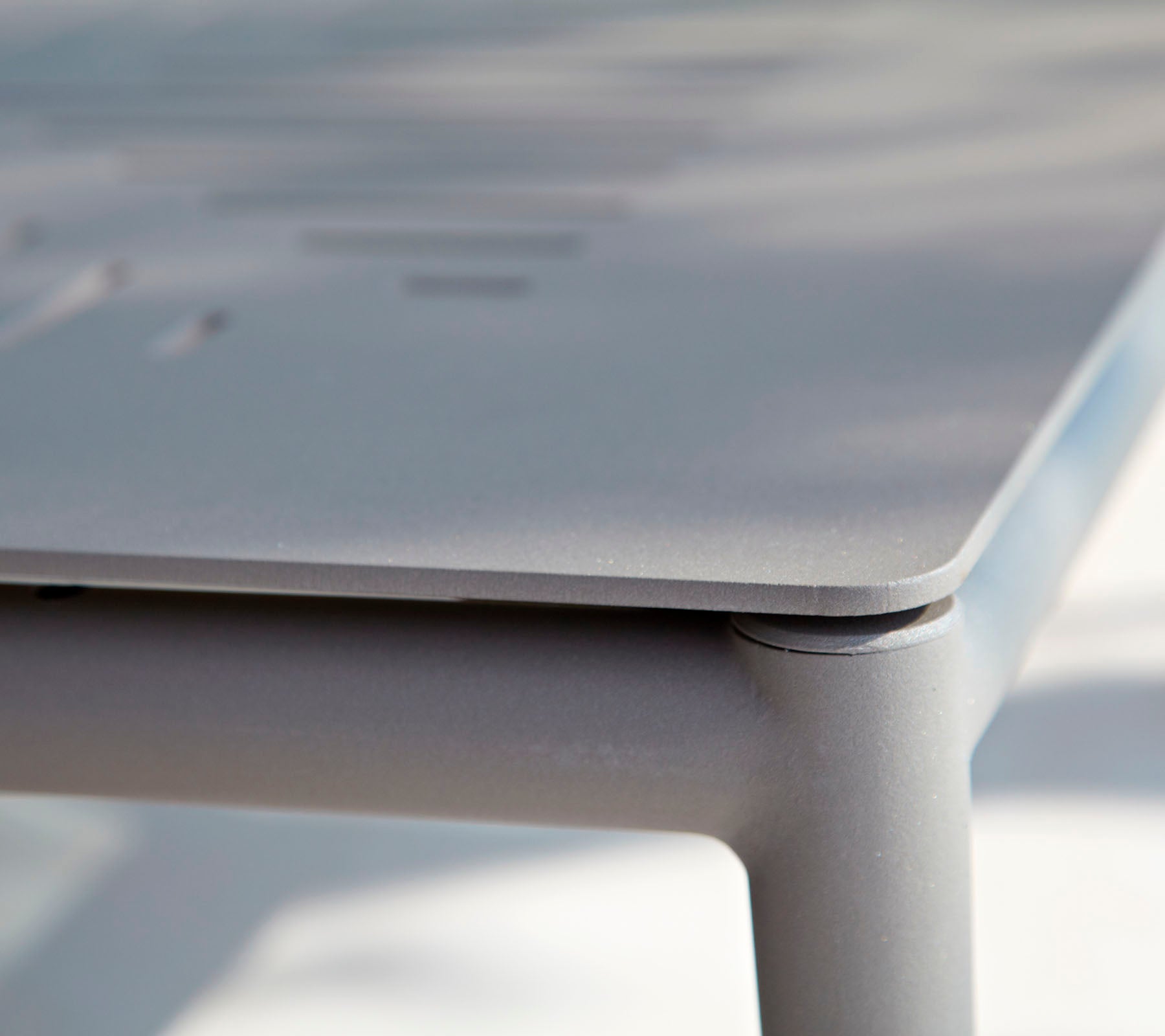 Close-up van een elegant, modern tafeltje met een glad oppervlak en subtiele details. Het ontwerp benadrukt strakke lijnen en minimalistische stijl.