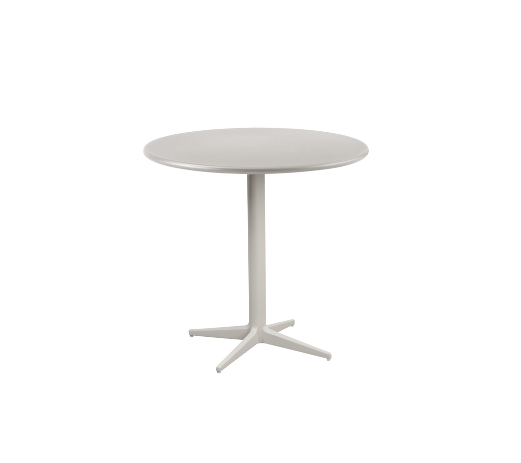 Een zandkleurige ronde tafel met een minimalistisch ontwerp.