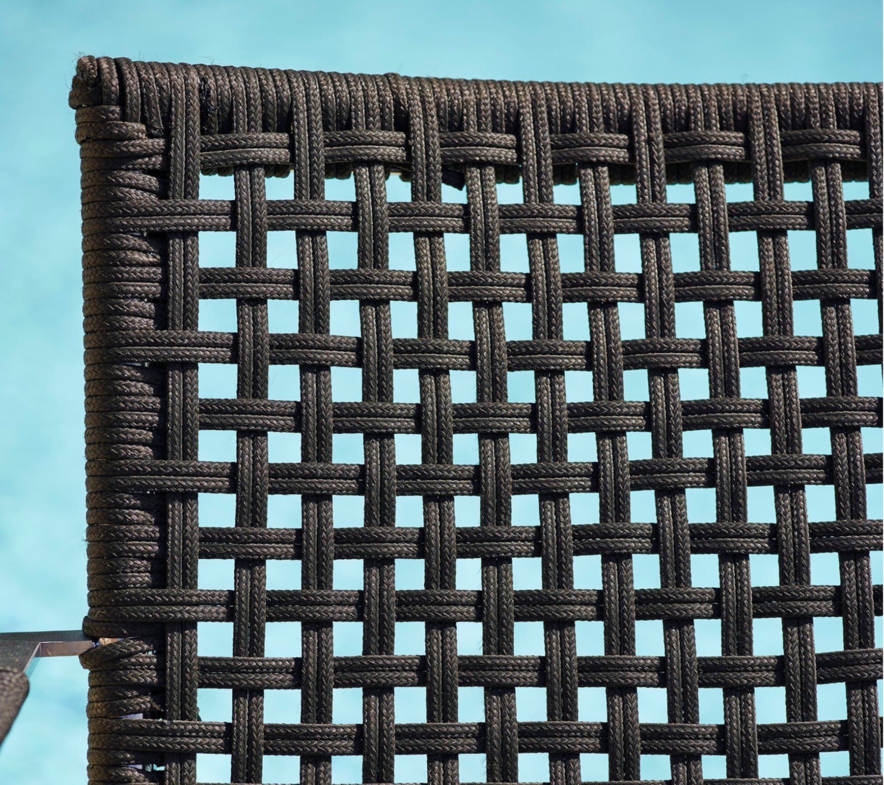 Gedetailleerde close-up van een geweven zwart materiaal, dat een gestructureerd patroon laat zien dat geschikt is voor meubels of decor.
