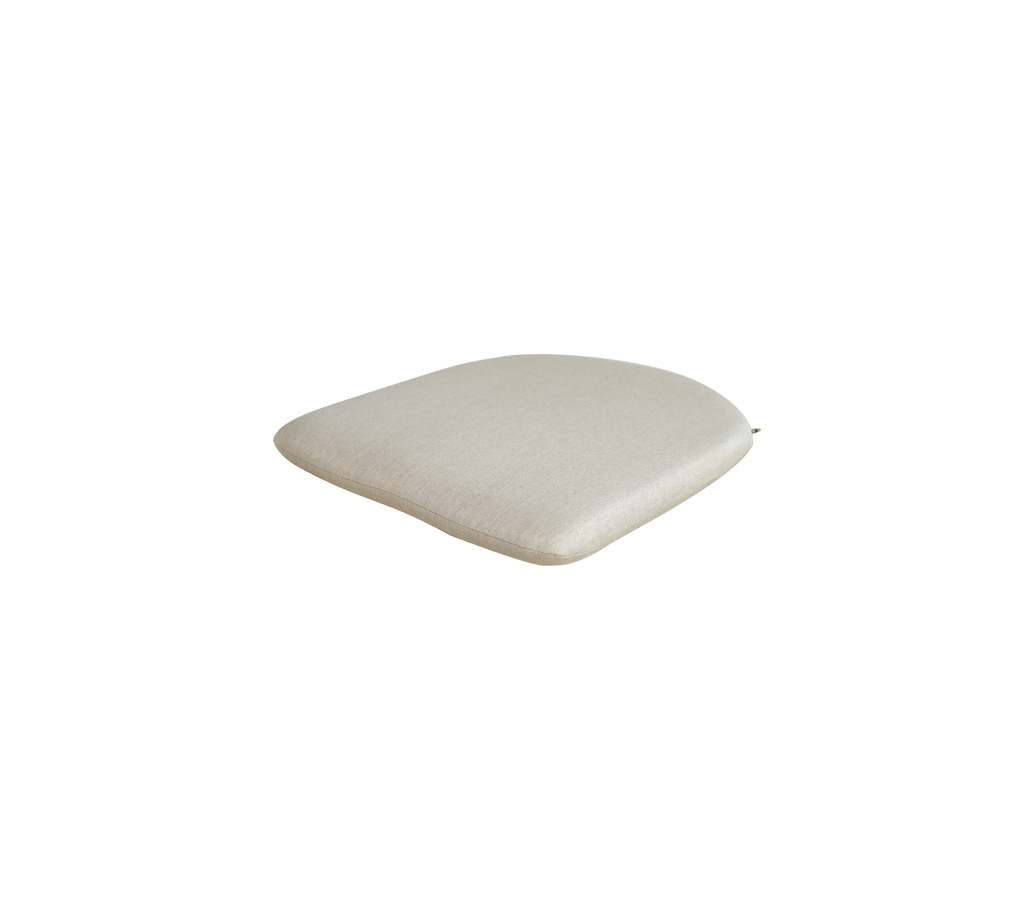 Zandkleurig kussen met een glad, rond uiterlijk.