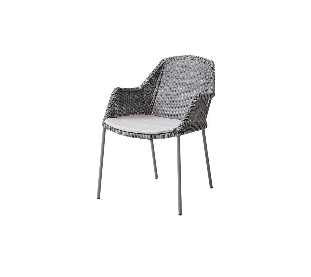 Stijlvolle grijze geweven stoel met een comfortabele witte kussen, perfect om moderne flair aan elke ruimte toe te voegen.