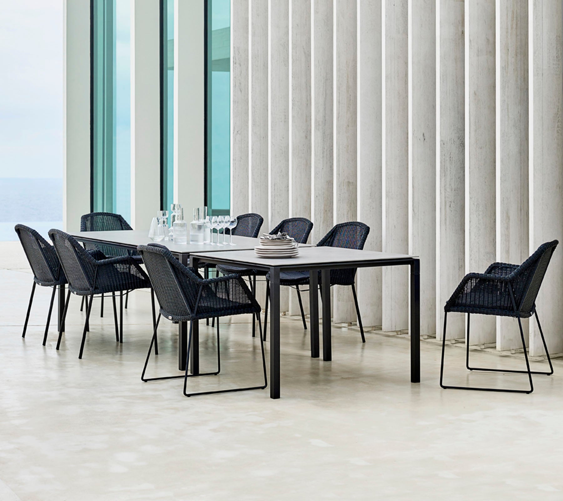 Een moderne eettafelset met zwarte stoelen eromheen, met minimalistische designelementen en een elegante tafelsetting.