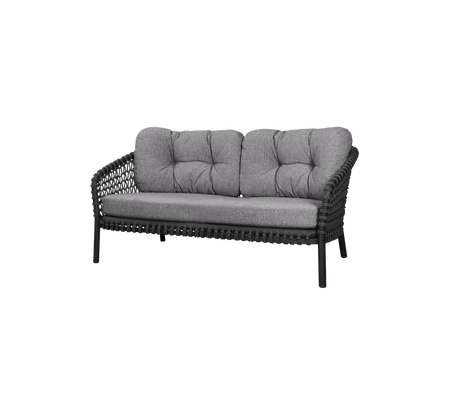 Twee-zits bank met een gevlochten frame en zachte grijze kussens, ontworpen voor comfort en stijl. Perfect voor zitplaatsen in elke ruimte.
