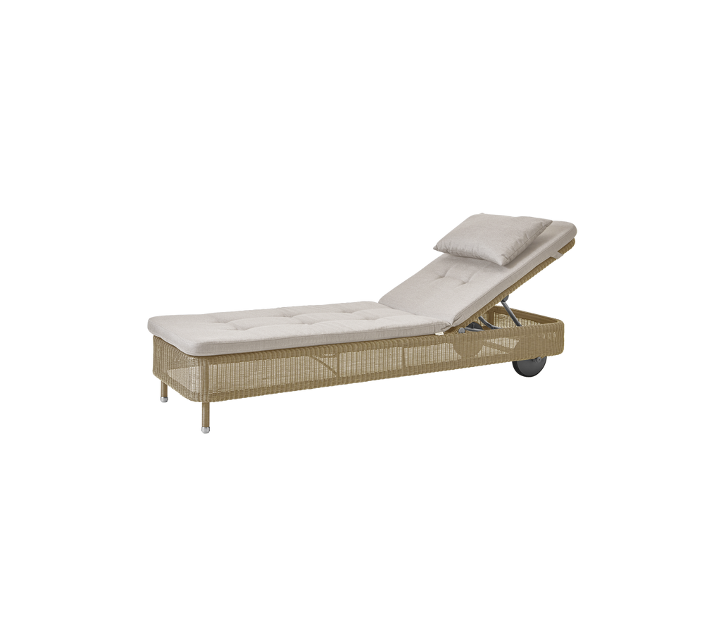 Minimalistische loungechair met zandkleurige kussen.