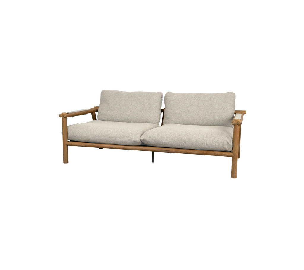 Moderne teaksofa met woestijnzand kussens.