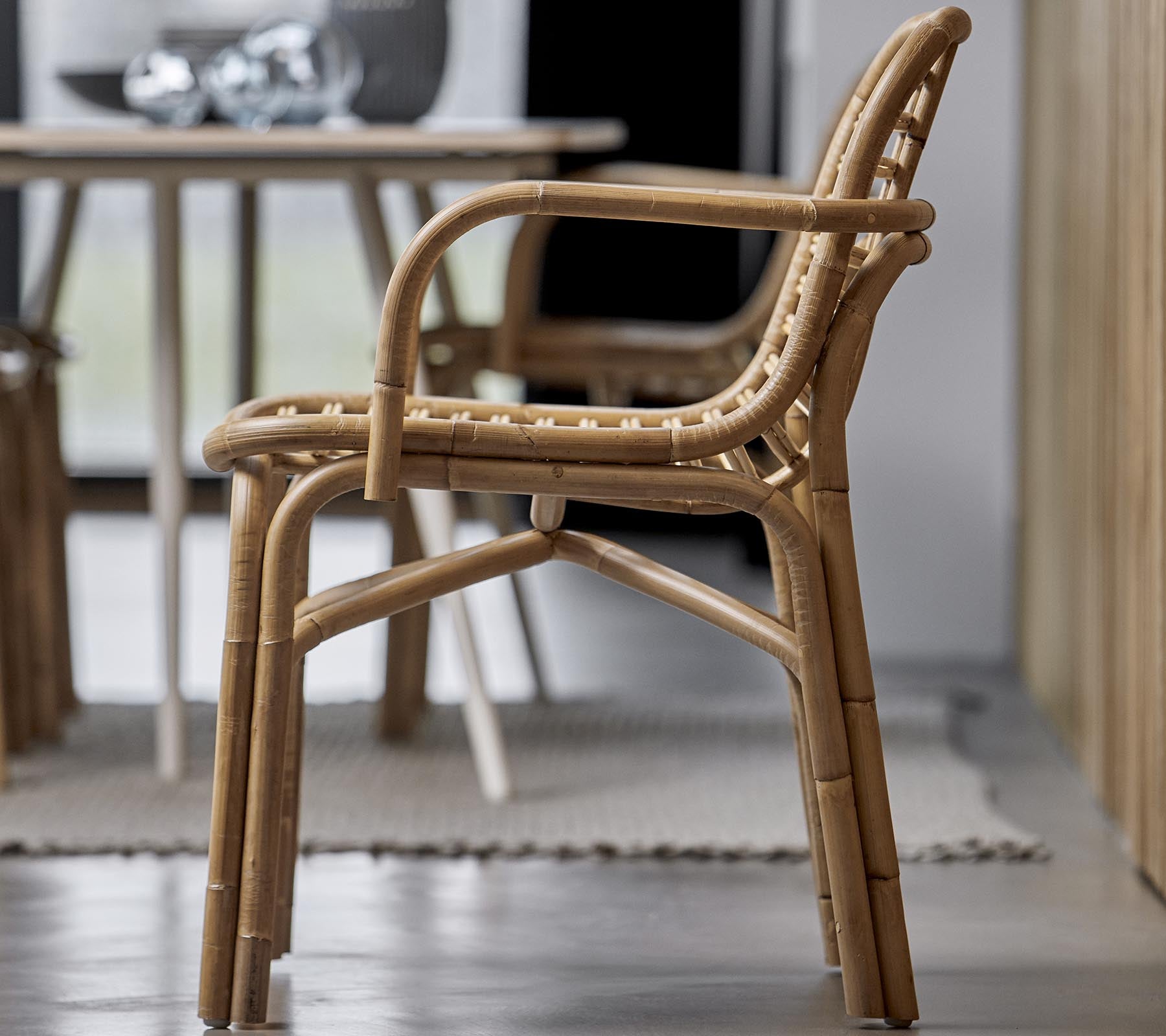 Een stijlvolle stoel gemaakt van natuurlijke materialen, met een geweven ontwerp en armleuningen, geschikt voor verschillende interieursettings.