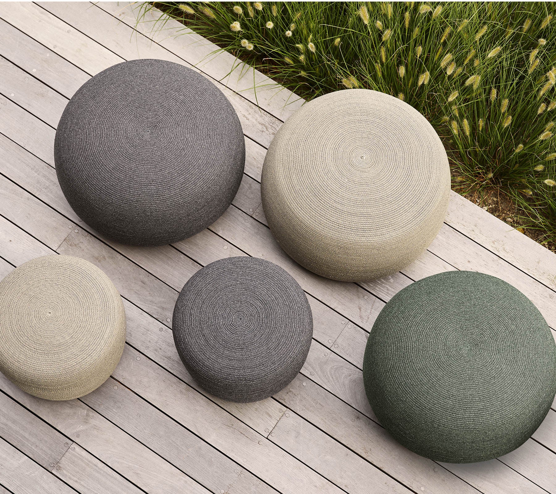 Een set van vijf ronde poufs in verschillende maten en kleuren, met textuur oppervlakken die een modern tintje aan elke ruimte toevoegen.
