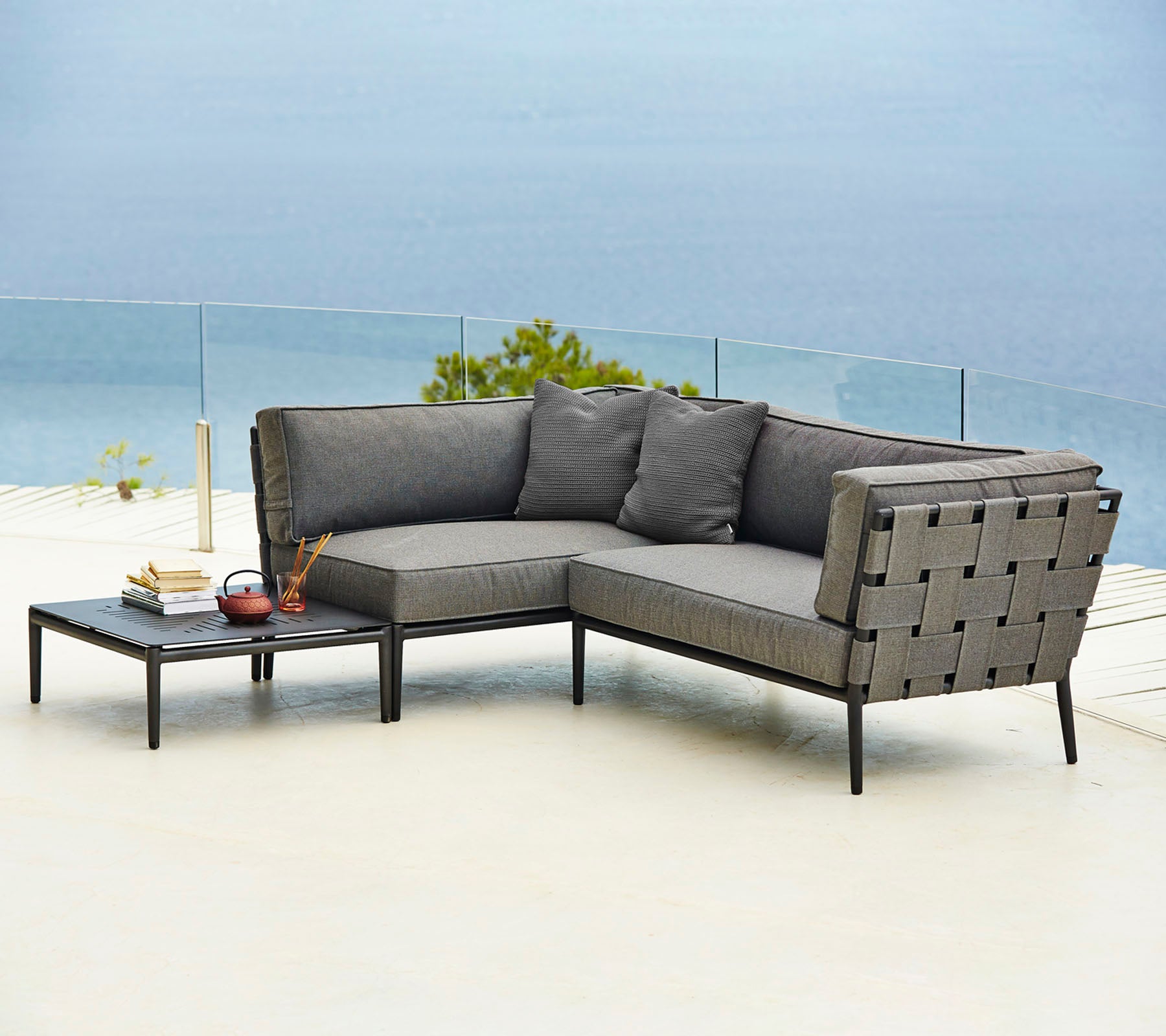 Stijlvolle buitensectie sofa met comfortabele kussens en een bijpassende salontafel, perfect voor ontspanning en plezier.