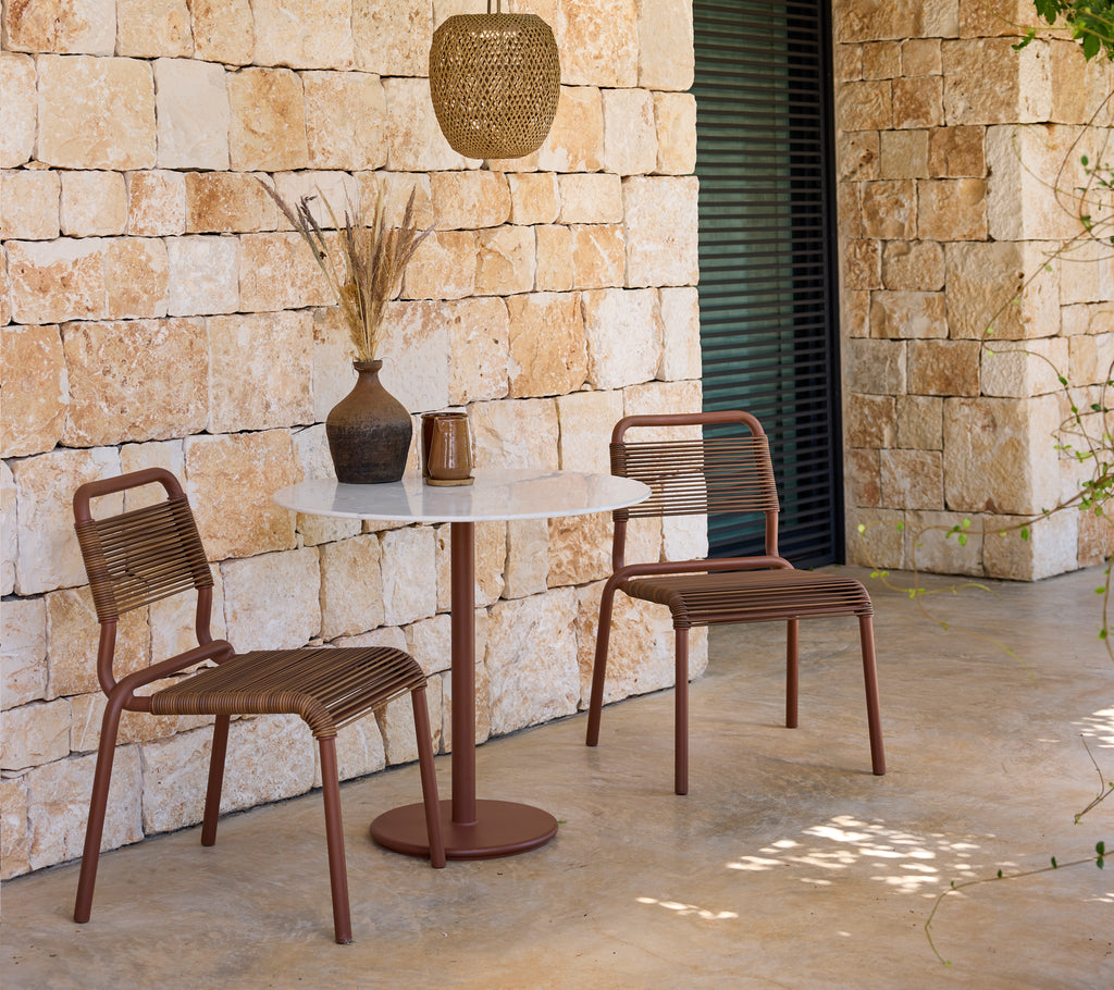 Moderne loungeopstelling met bruine stoelen en een witte tafel.