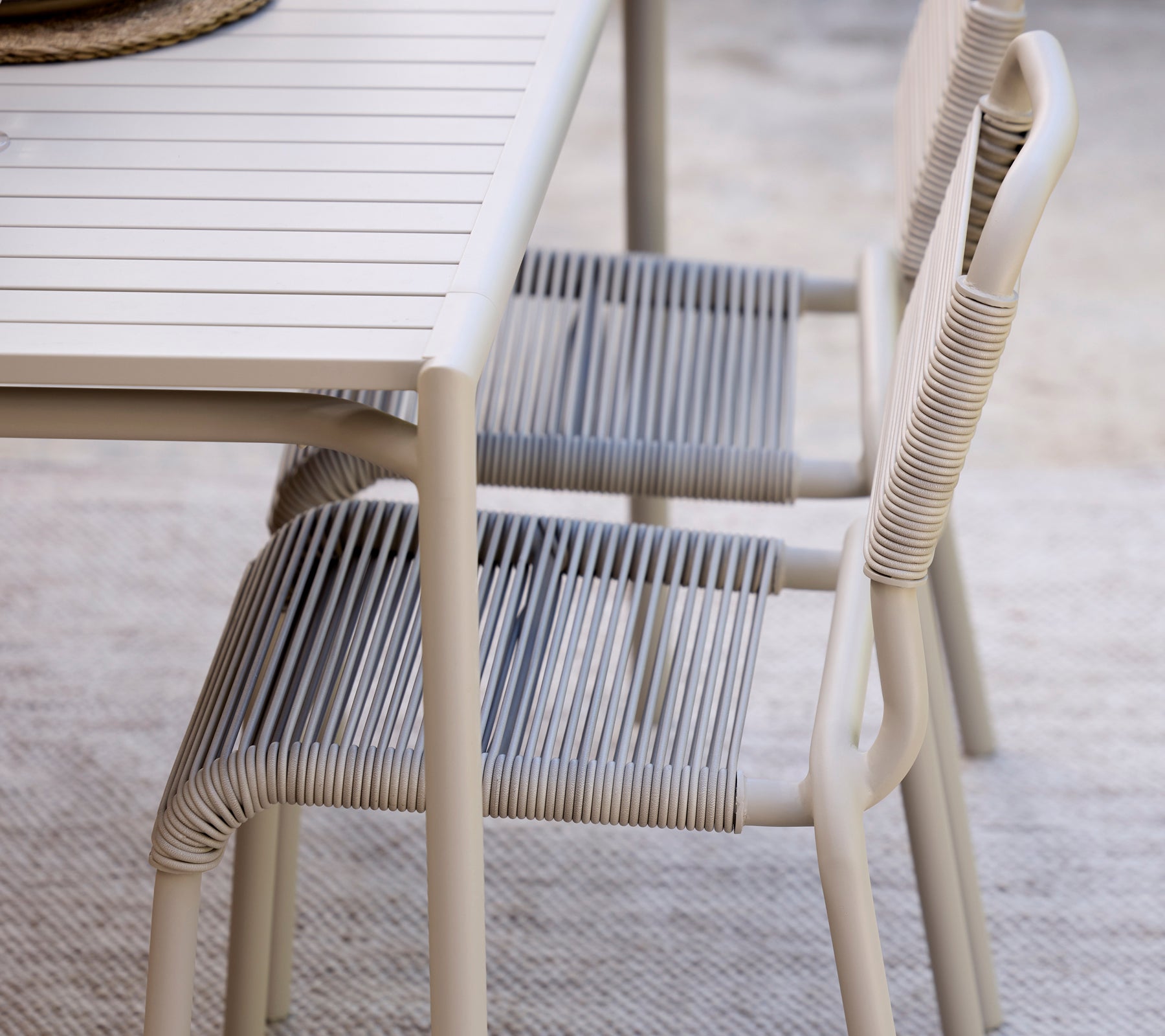 Moderne grijze eettafel in combinatie met gestreepte stoelen.