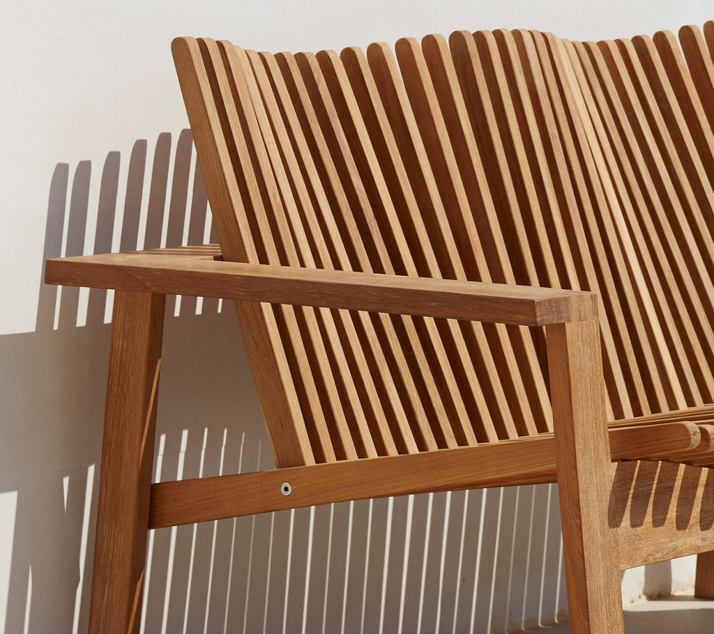 Zijaanzicht van een stijlvolle 2-zits bank met een lattenrugleuning en houten armleuning, die een modern design laat zien.
