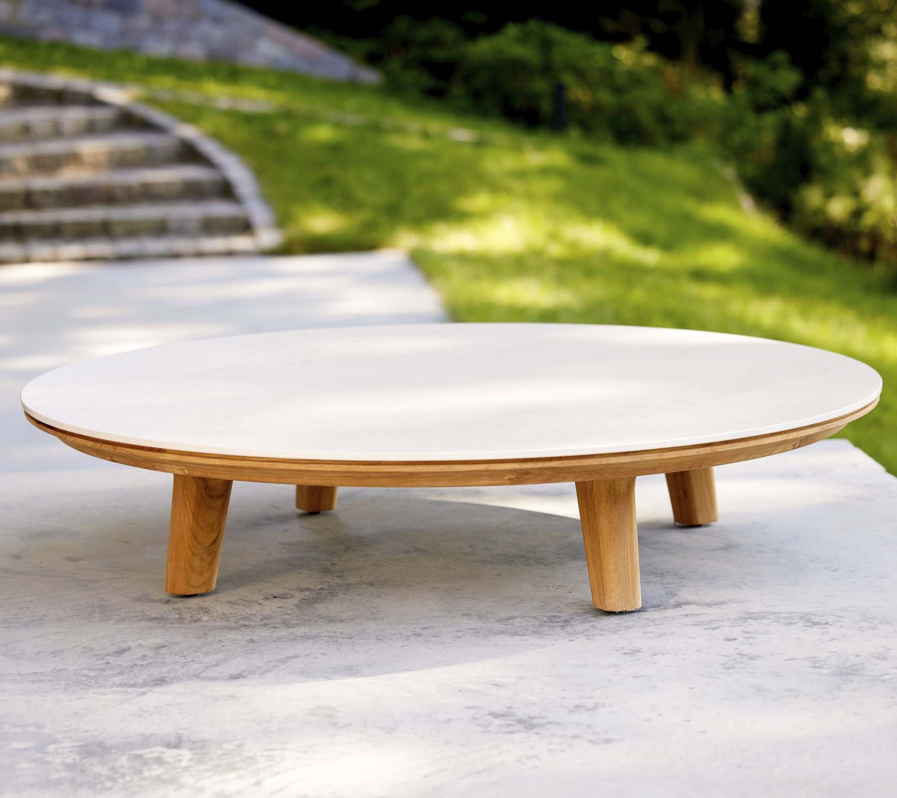 Modern rond salontafel met een gladde oppervlakte en houten benen, met een minimalistisch ontwerp dat geschikt is voor verschillende omgevingen.