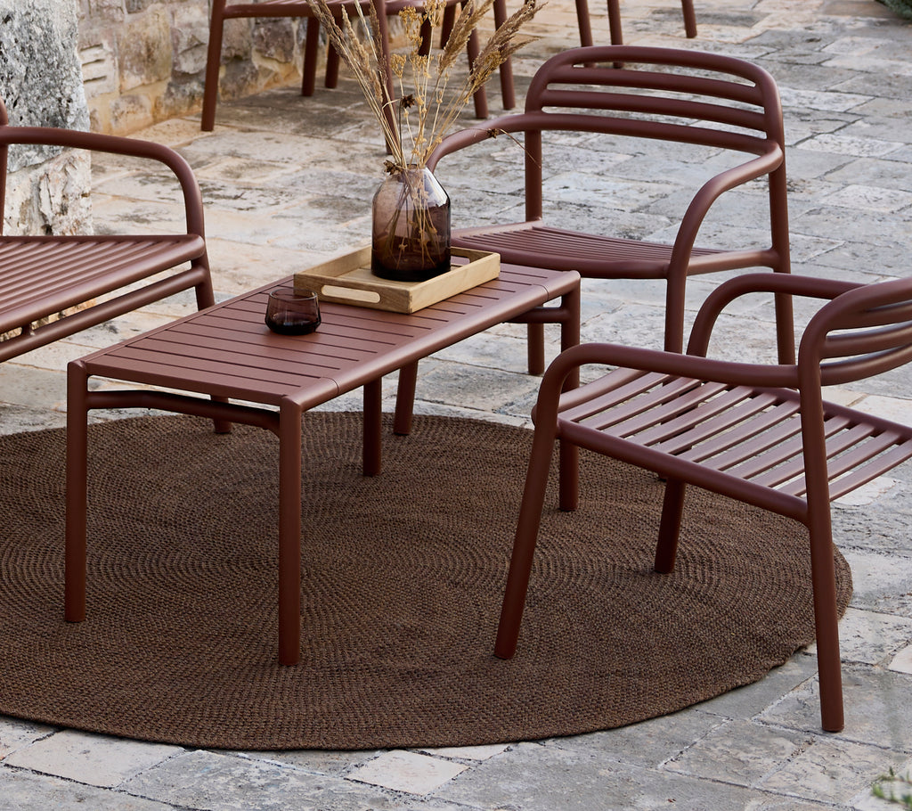 Minimalistische bruine tafel en stoelen gerangschikt in een lounge-setting.