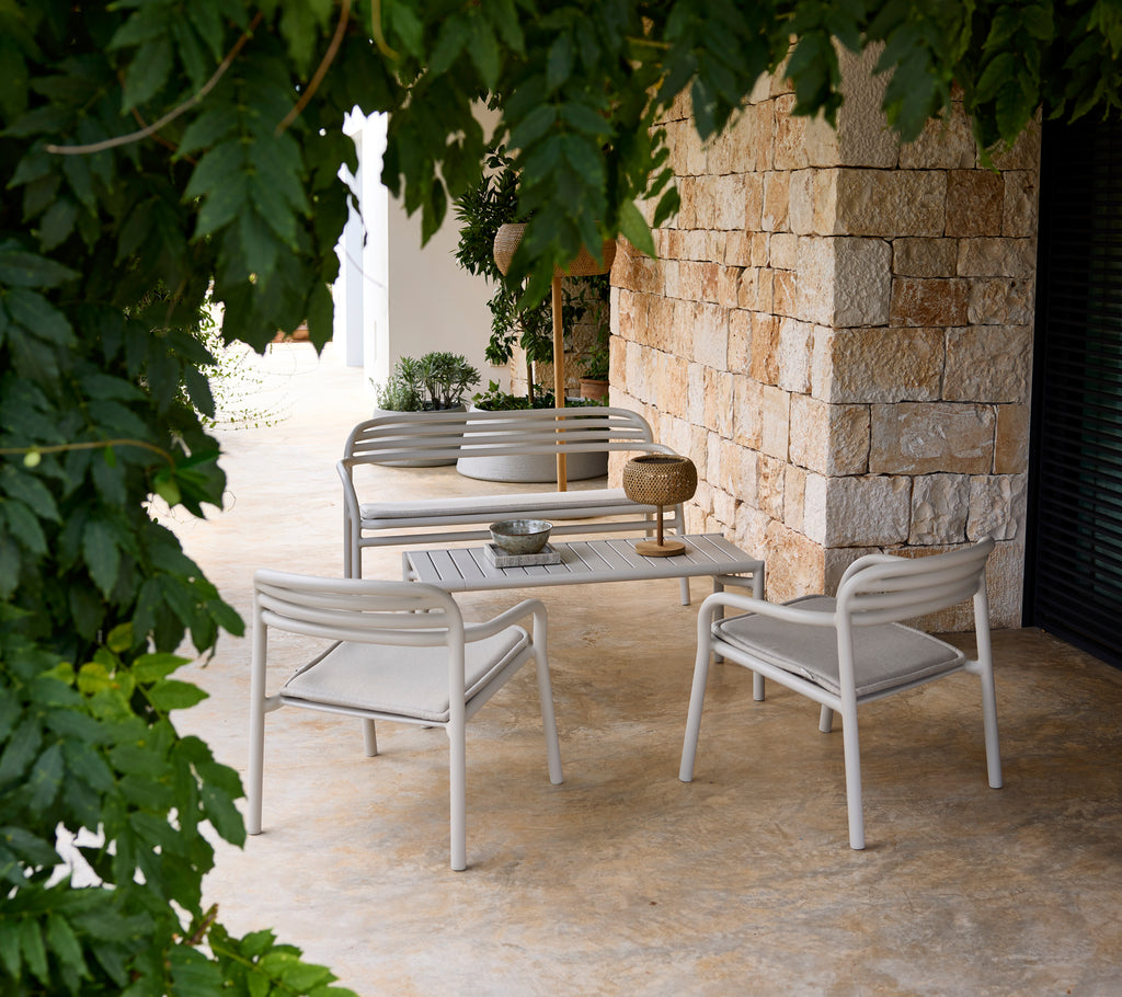 Grijze bank en stoel met een witte tafel in een moderne lounge-instelling.