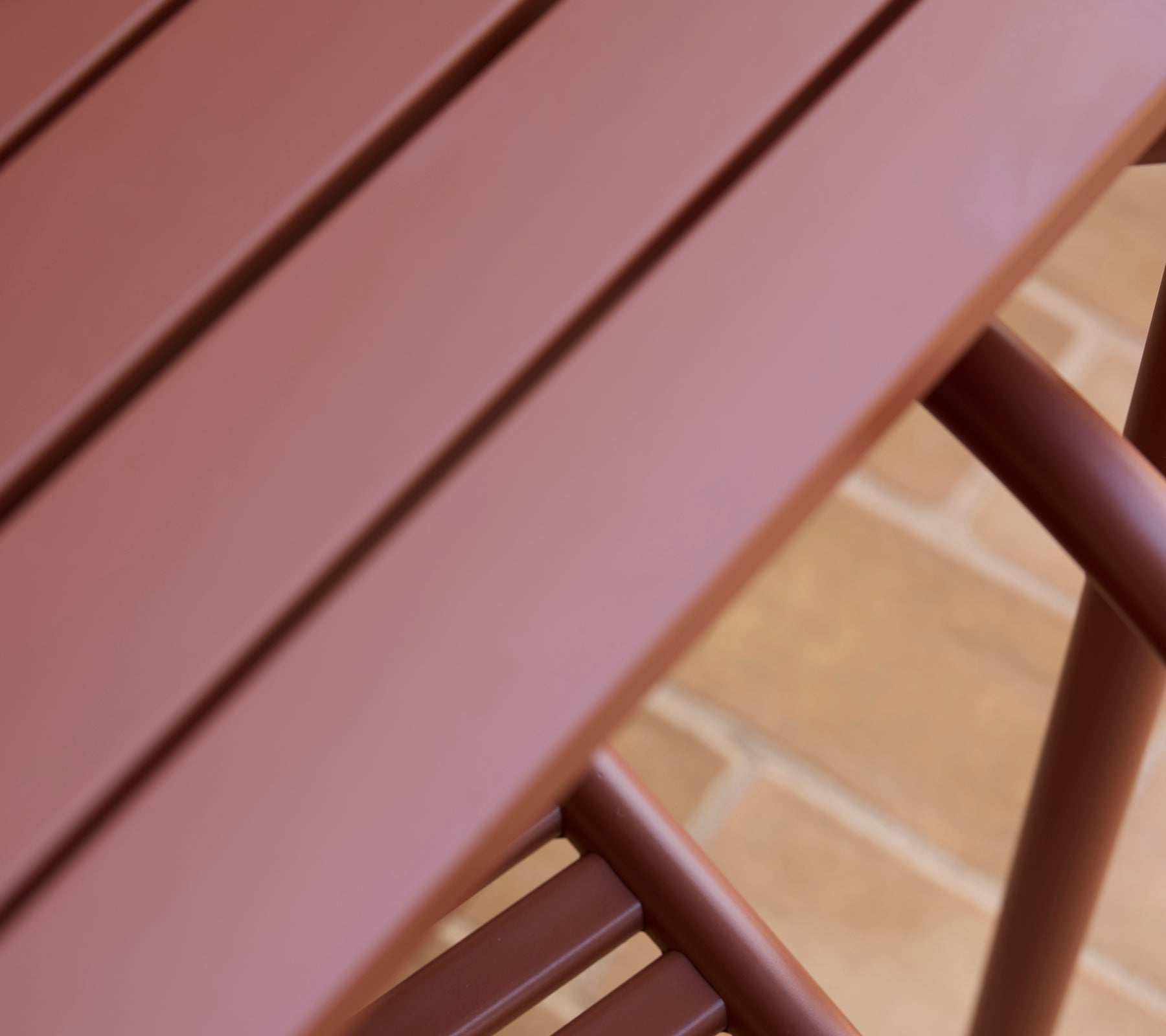 Een close-up van een woestijnrode Bliss-tafel die zijn gladde oppervlak en slanke ontwerp toont.