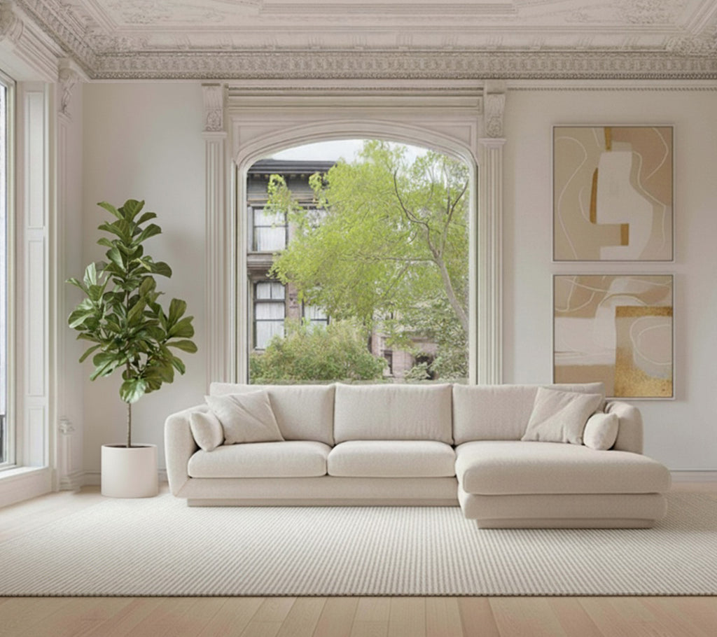 Beige hoekbank met een groene plant en een wit tapijt in een moderne lounge-instelling.