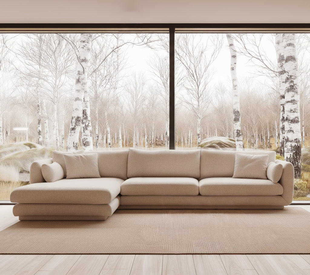 Beige moderne bank in een lichte lounge-instelling met grote ramen.