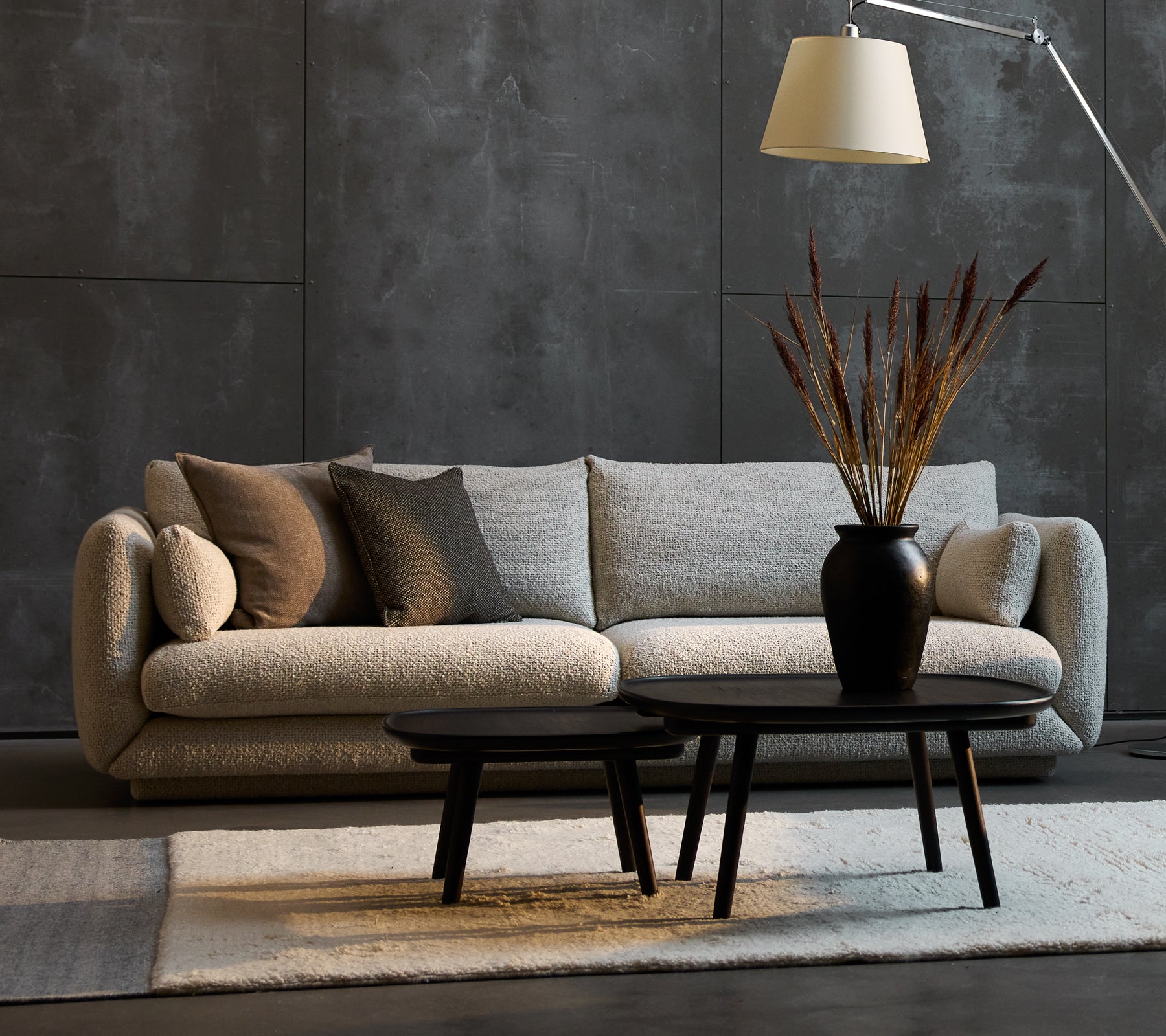 Bloom 3-zits bank in zandkleur met decoratieve kussens, vergezeld van twee Pace salontafels in verschillende maten en een stijlvolle vloerlamp.