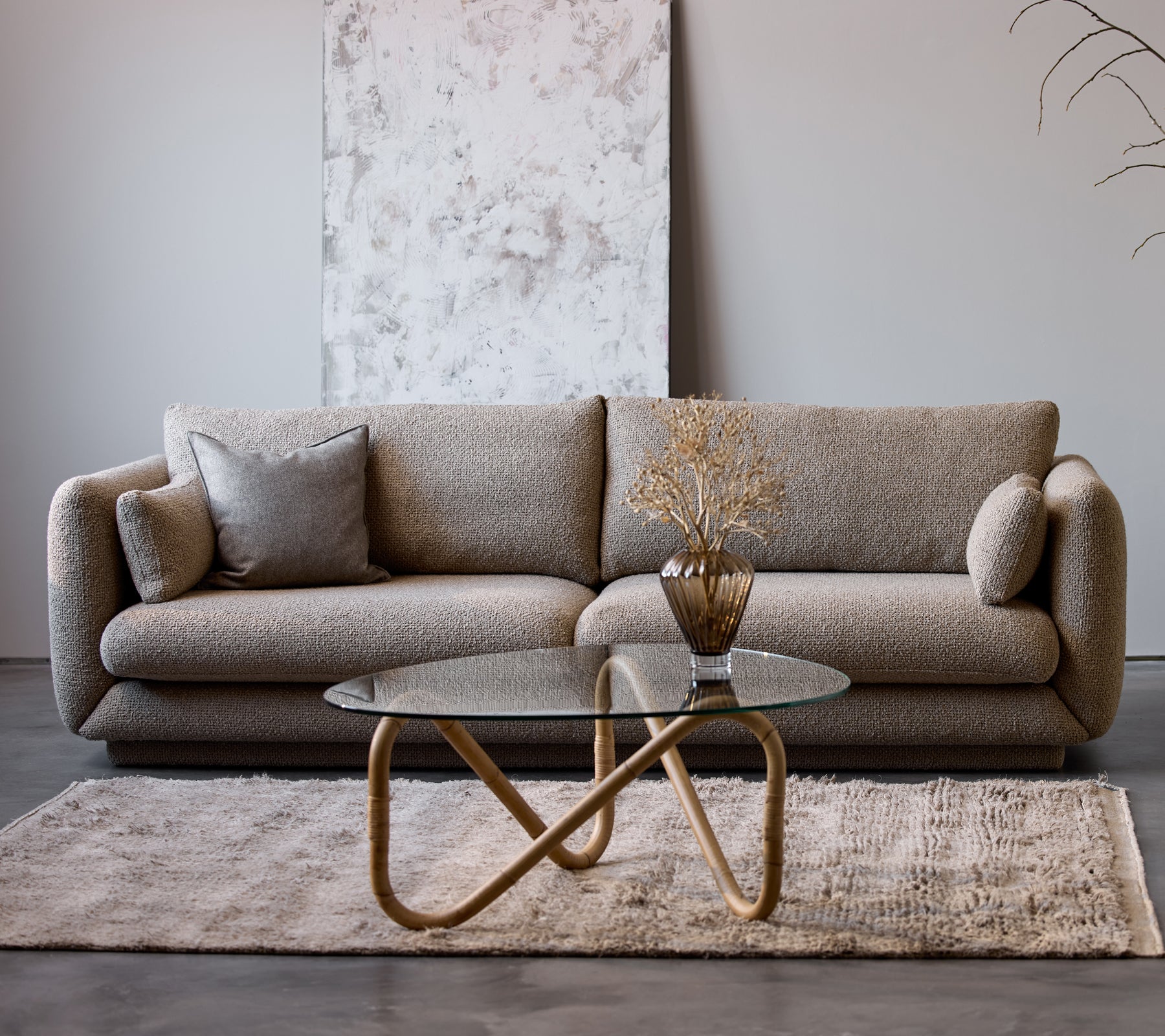 Bloom 3-zitsbank in taupe flair met een plint, gecombineerd met een Wave binnen koffietafel en een decoratieve vaas, op een zacht tapijt.