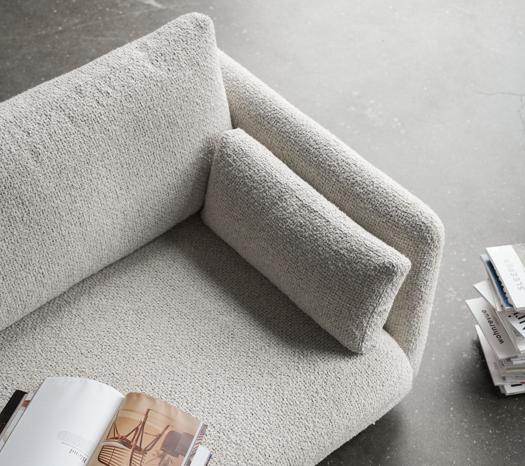 Stijlvolle sofa met een textuur oppervlak, voorzien van een zacht armleuning en een comfortabele kussen, perfect om te ontspannen en te lezen.