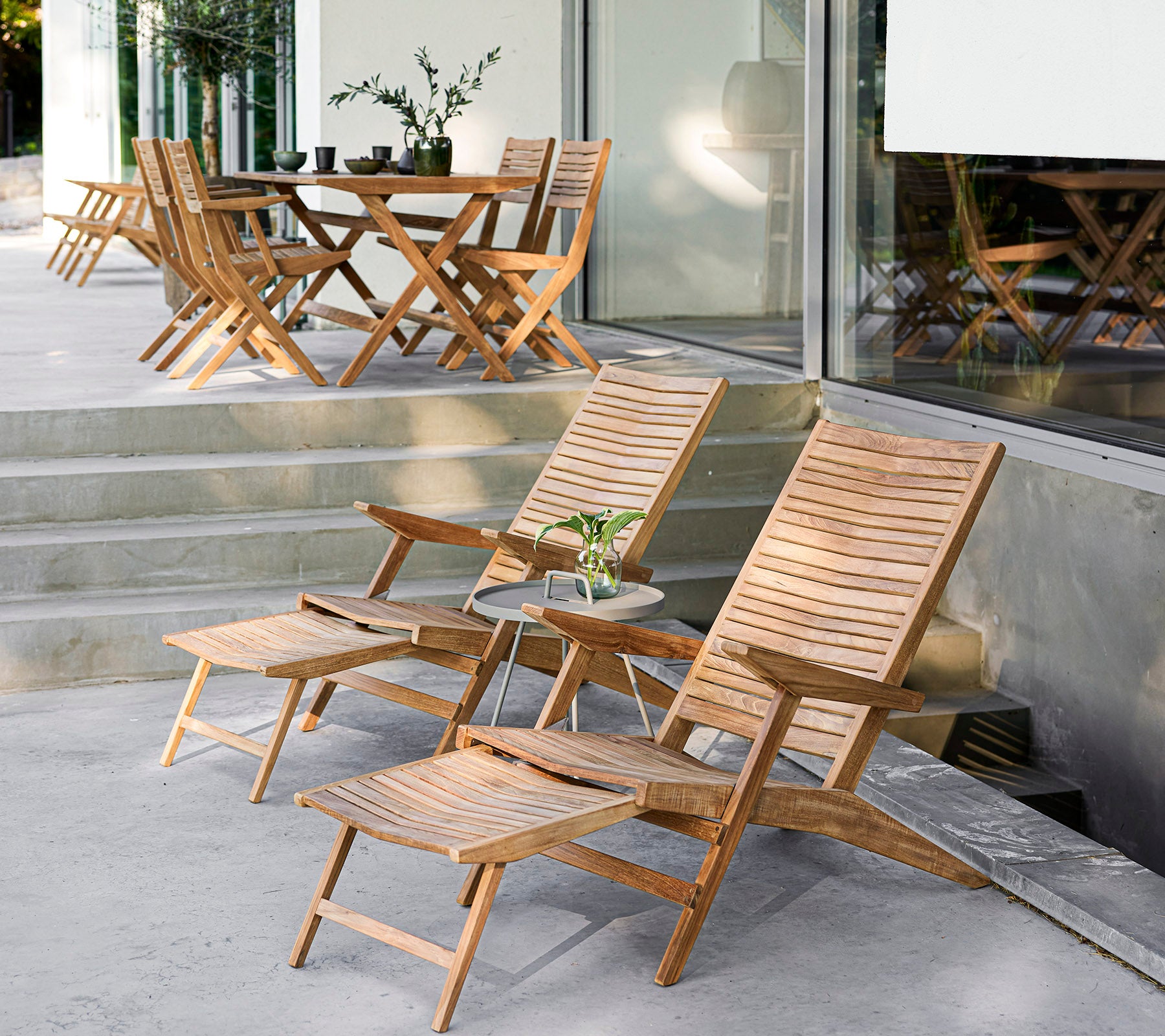 Stijlvolle houten meubelset met ligstoelen, een bijzettafel en een eettafel, perfect voor gezellige bijeenkomsten en ontspanning.