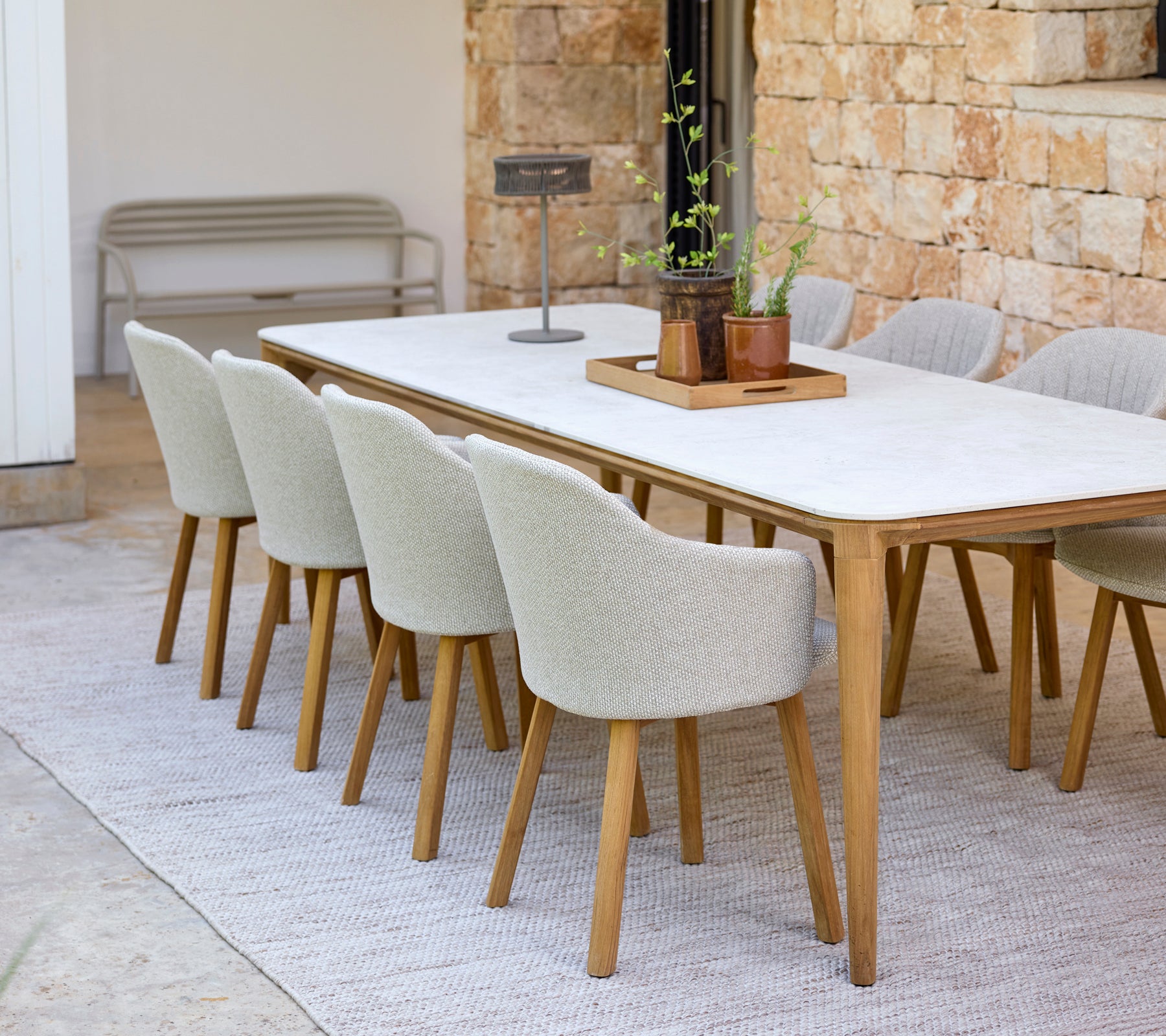 Moderne eetopstelling met een witte tafel en beige stoelen.