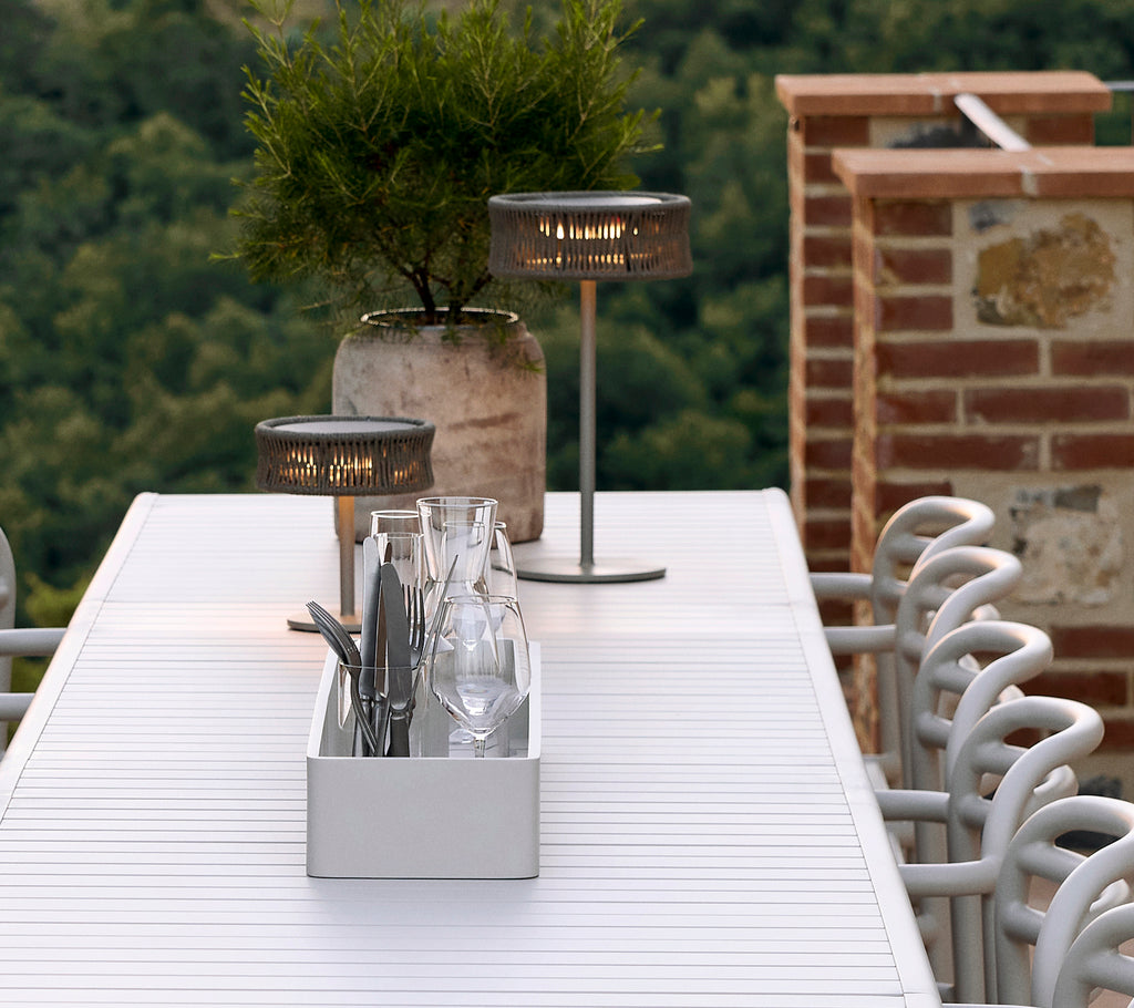 Aluminium clubopslagdoos op een tafel met Illusion-lampen, een decoratieve vaas en glazen netjes gerangschikt.