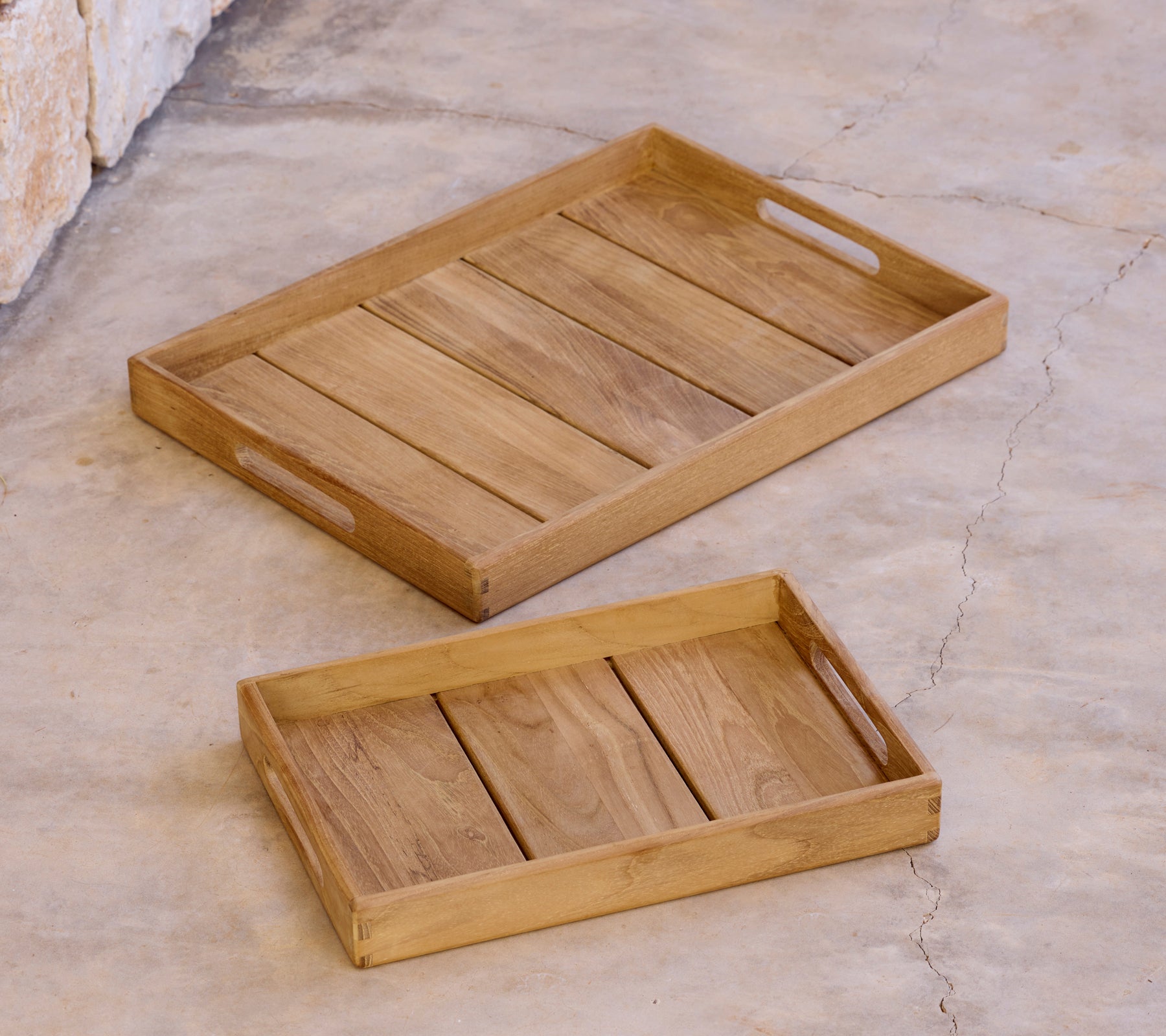 Twee houten schalen van verschillende maten op een oppervlak geplaatst.