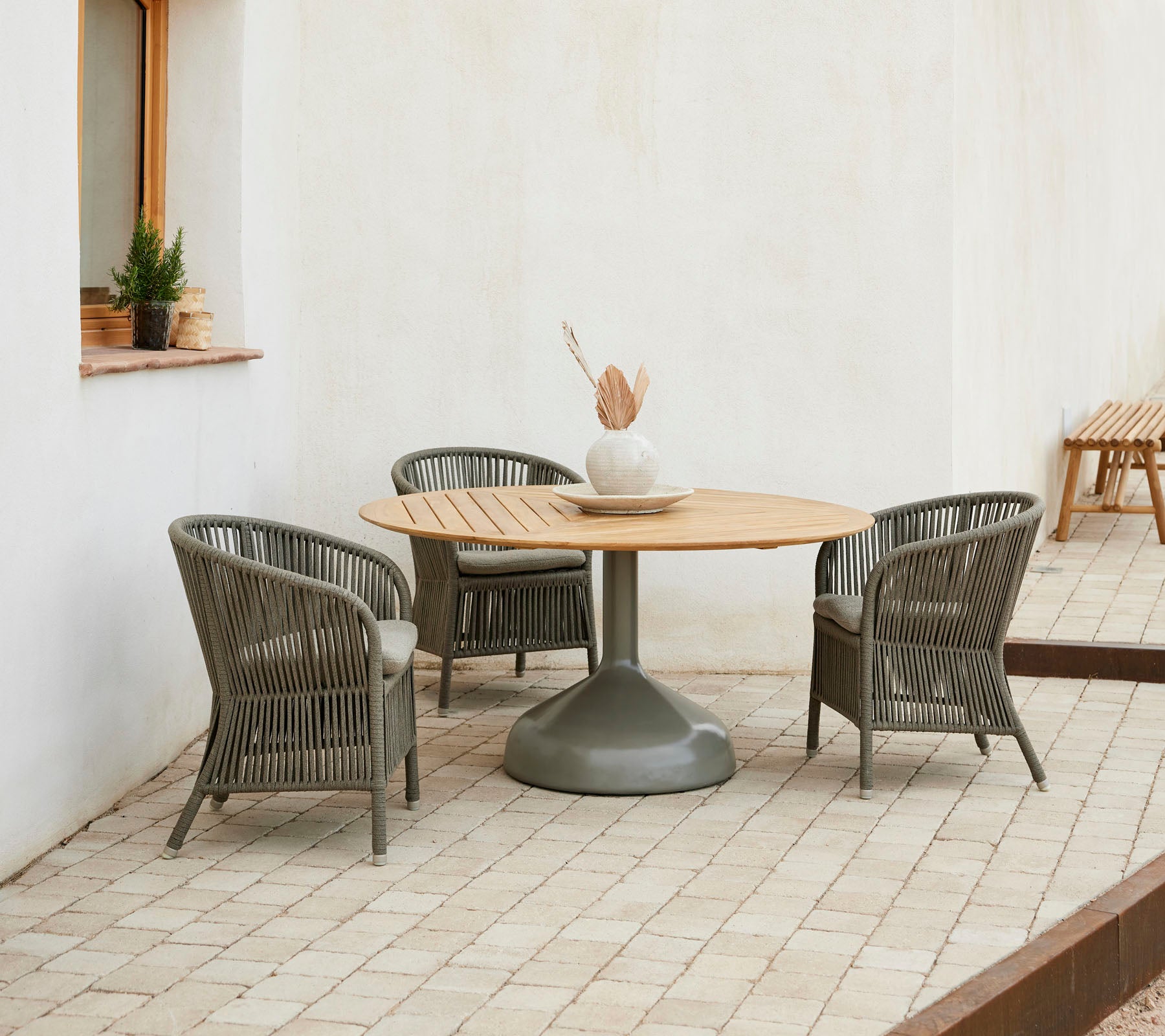 Een stijlvolle eetopstelling met een ronde houten tafel omringd door elegante Derby-stoelen, die een uitnodigende sfeer creëert.