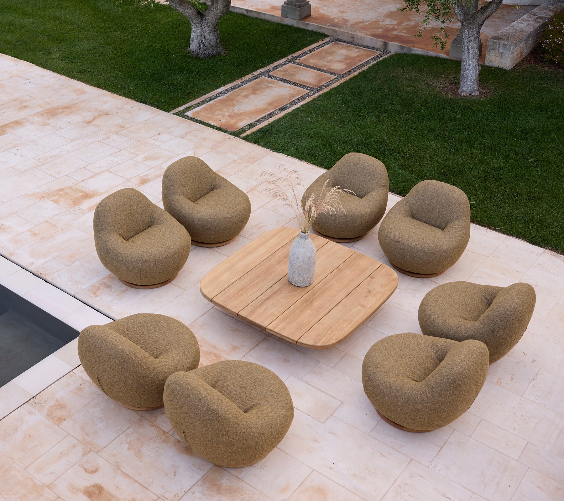 Moderne lounge-inrichting met beige stoelen en een houten tafel.