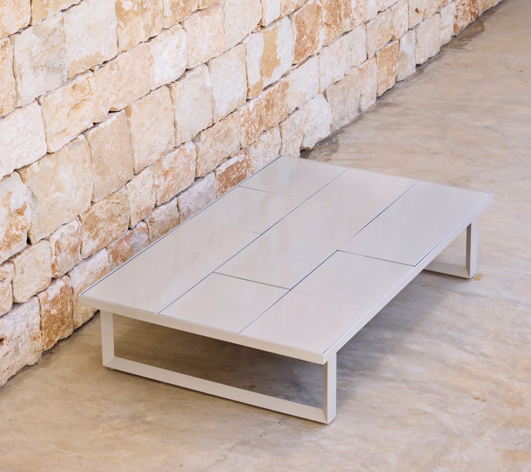 Moderne grijze salontafel met een minimalistisch ontwerp in een natuurlijke omgeving.