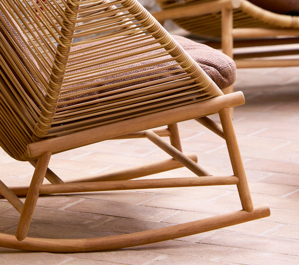 Een close-up van een houten schommelstoelbasis met een geweven ontwerp, dat de gebogen zitting en stevige structuur laat zien.