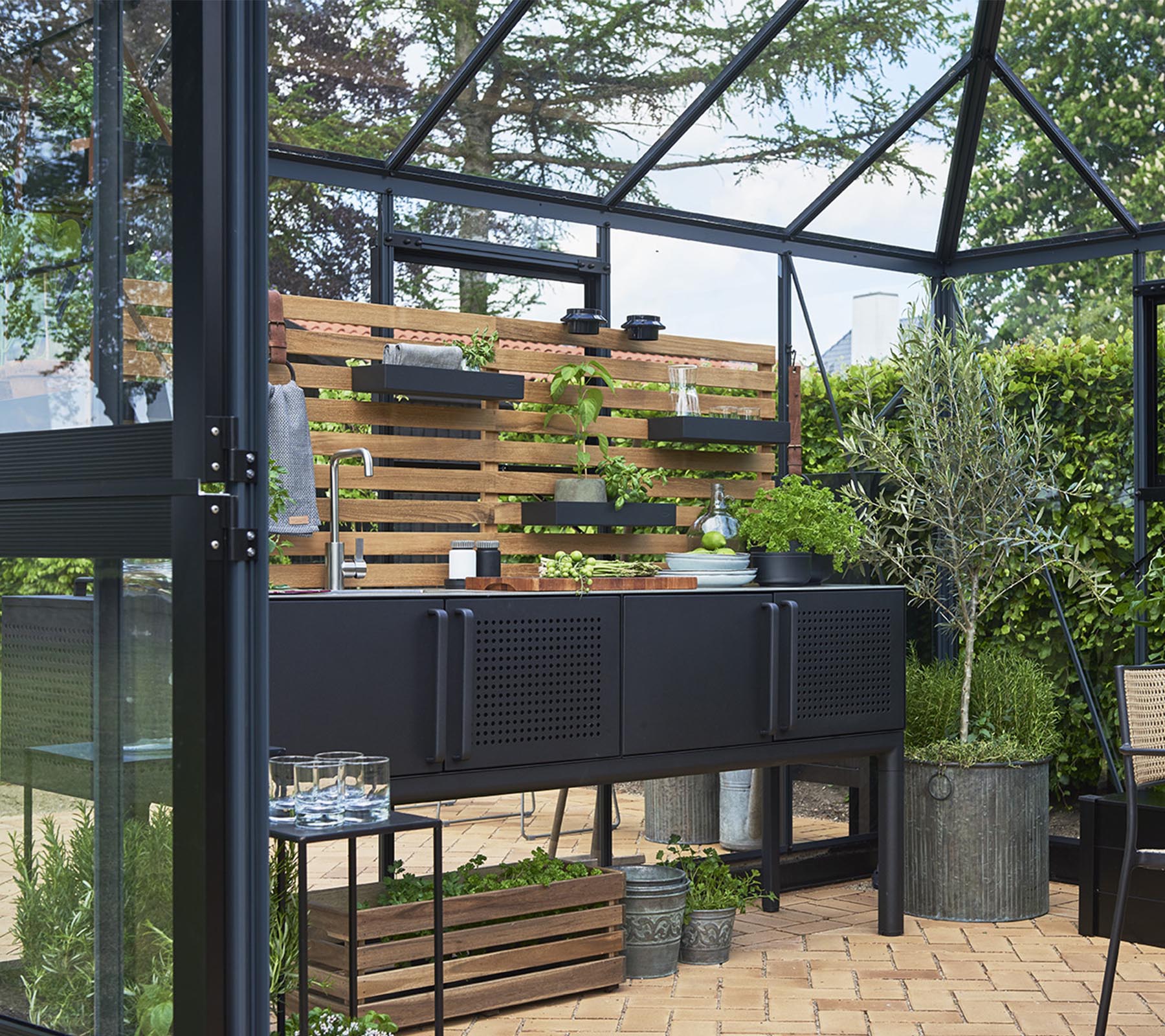 Een moderne opbergunit met planten op houten planken, omringd door groen en decoratief ingericht met verschillende plantenpotten.