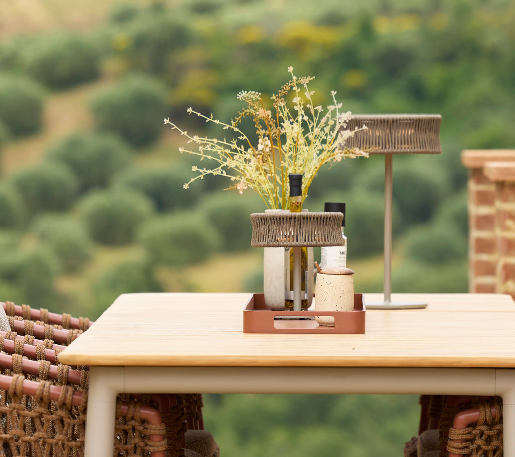 Een stijlvol eettafel met een illusielamp en een vaas met bloemen, die een elegant middelpunt creëert in een serene omgeving.