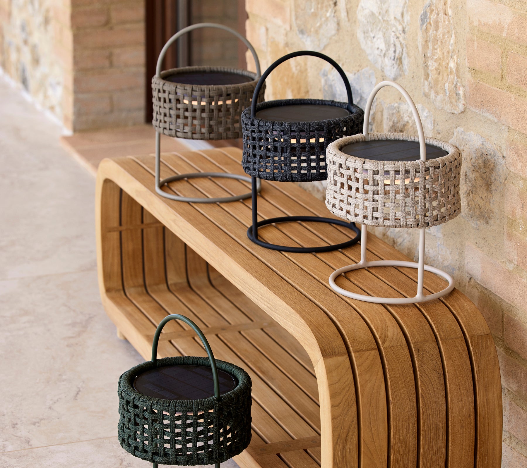 Een stijlvolle opstelling van vier illusielampen in verschillende kleuren op een strak houten oppervlak, die modern design en elegantie laat zien.