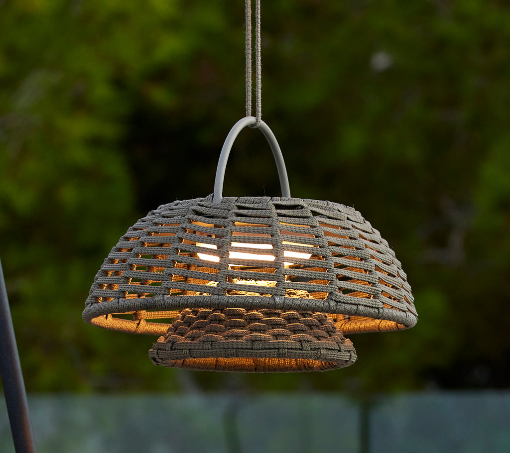 Taupe illusielamp met een geweven ontwerp, met een prominente koepelvorm en warm licht dat van binnenuit straalt, waardoor een uitnodigende sfeer ontstaat.