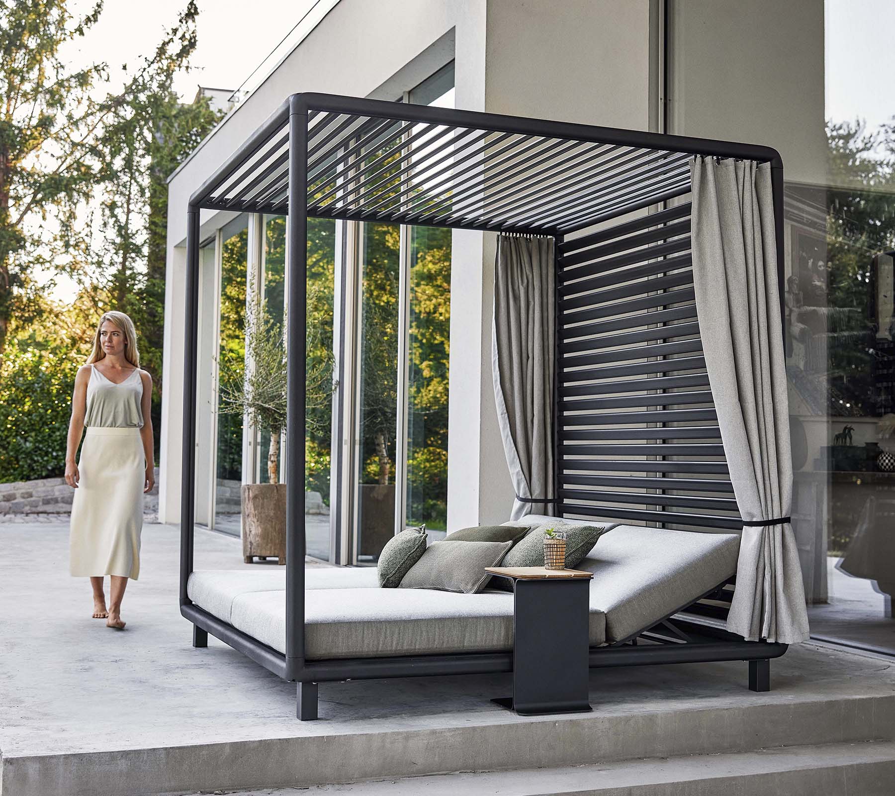Een stijlvolle cabana met een modern ontwerp, met een comfortabele loungehoek en zachte gordijnen, gelegen in een serene omgeving.