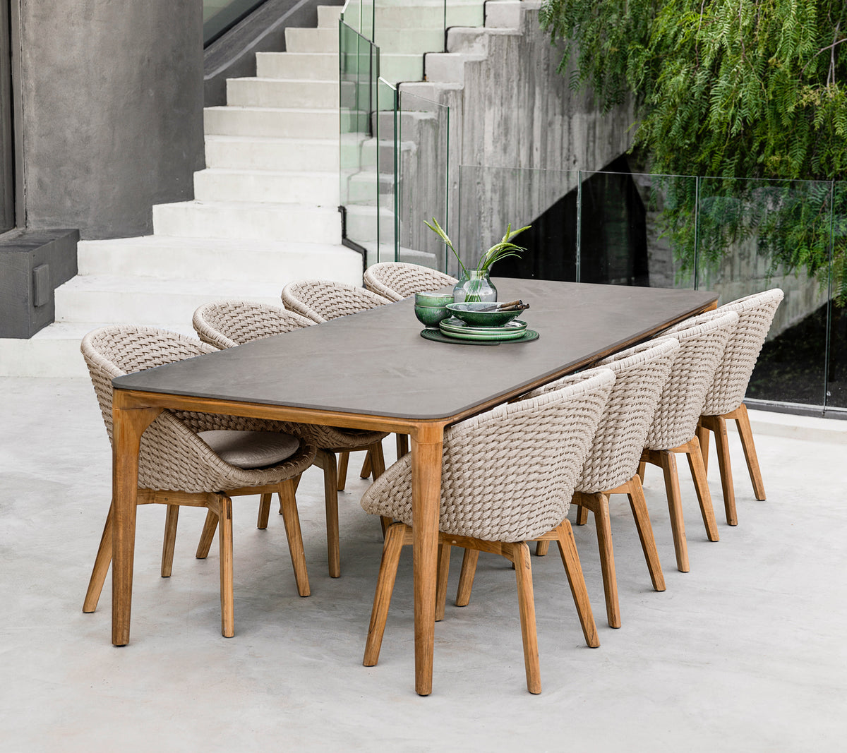 Modern bruine eettafel met gevlochten stoelen in een hedendaagse setting.