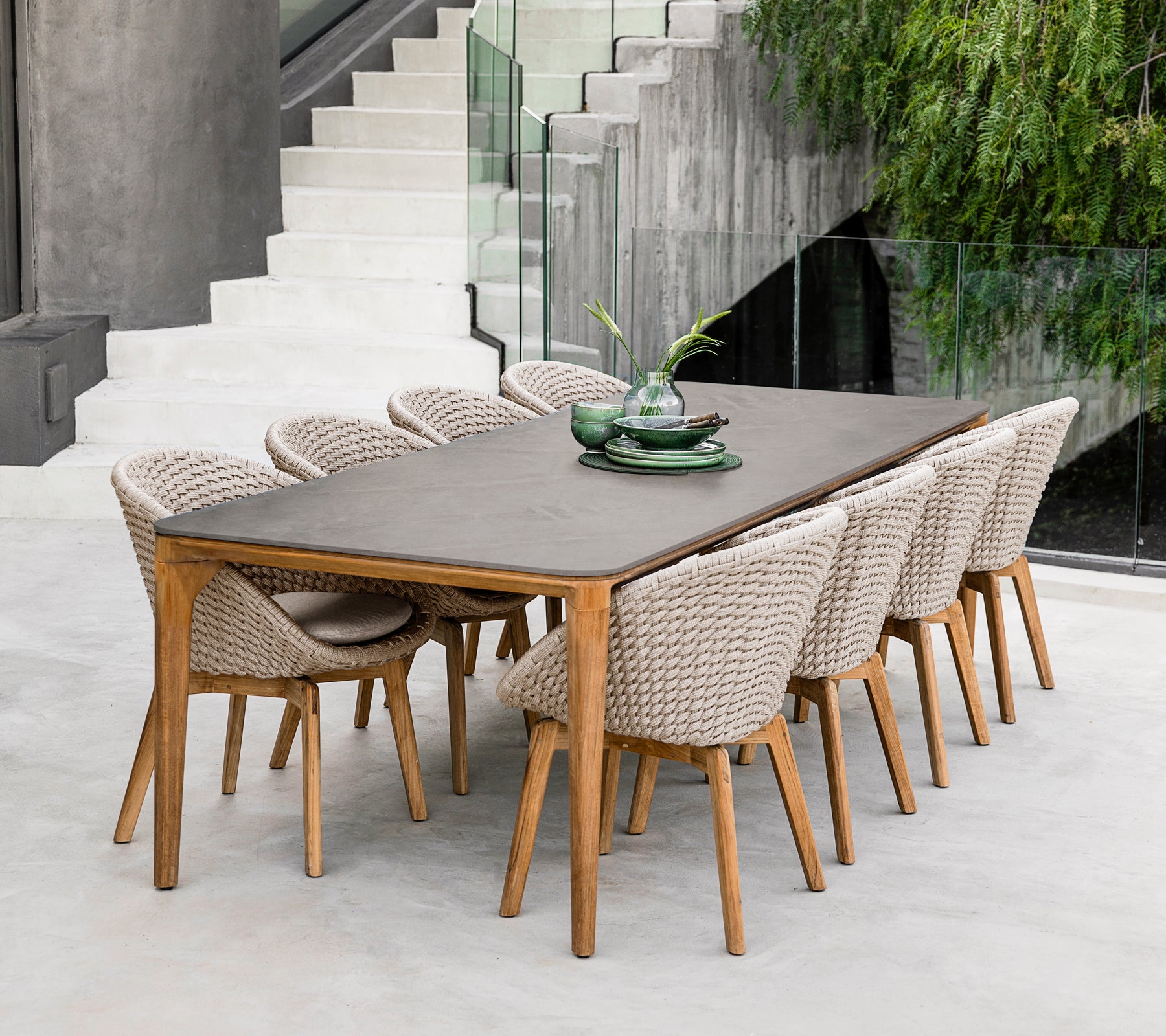 Modern bruine eettafel met gevlochten stoelen in een hedendaagse setting.