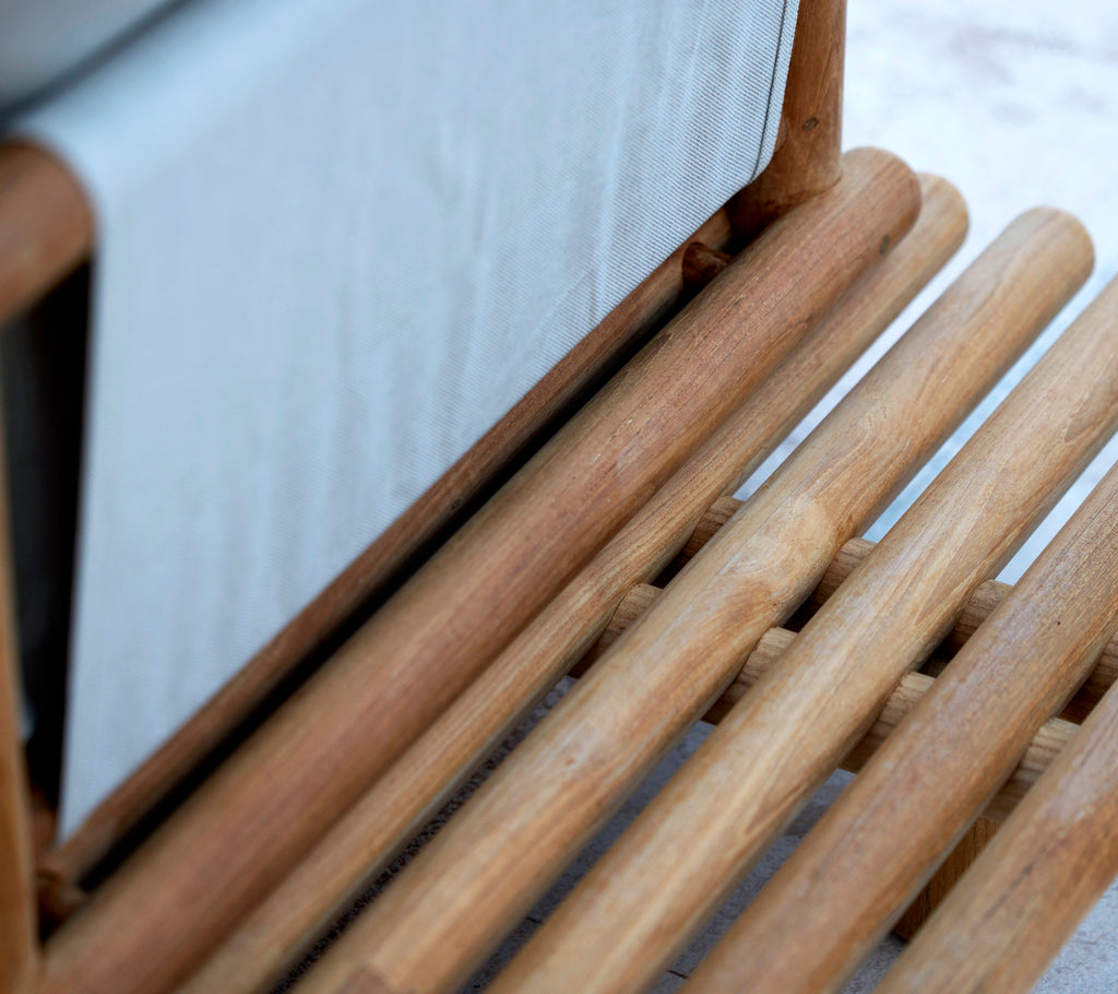 Teakhouten platform met een gladde houten staven, die een strak ontwerp en verborgen rugsteun voor extra comfort tentoonstelt.